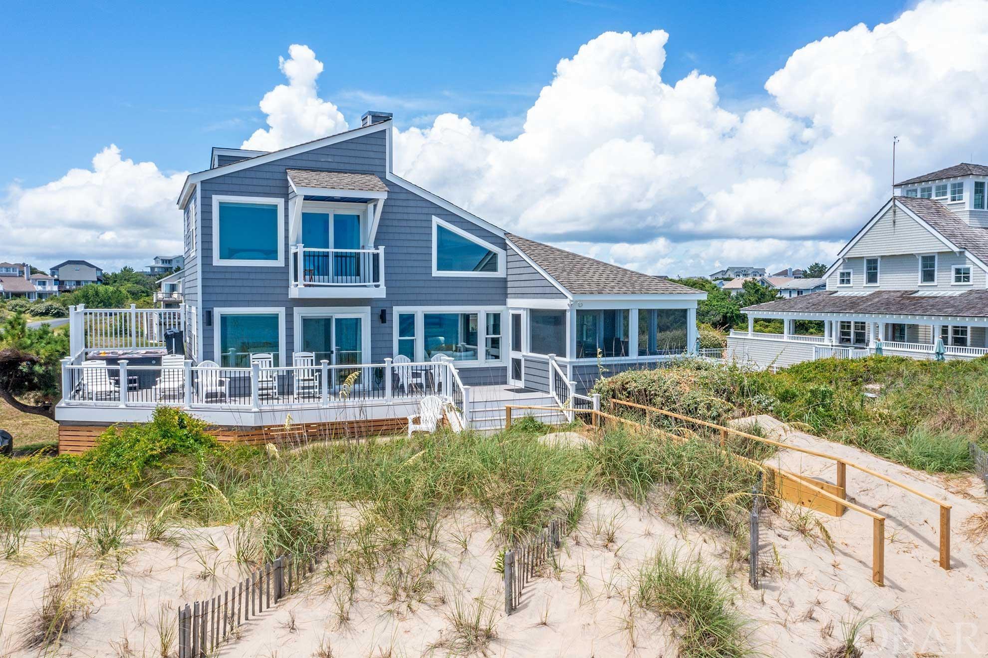 Step into unparalleled luxury with this recently renovated oceanfront masterpiece in the prestigious town of Duck. Outstanding investment opportunity with over $260,000 in gross rental income for 2023 with bookings in place for 2024.  Situated on a lot and a half, spanning a rare 120-feet of oceanfront, this opulent retreat offers panoramic ocean views from almost every room. This residence takes exclusivity a step further. Its proximity to Army Corps land provides an almost private beach experience, enhanced by recent beach nourishment. Substantial updates completed in 2022 and 2023 have elevated this estate to a realm of unmatched luxury. Within its open-concept layout, you'll find a state-of-the-art gourmet kitchen, replete with custom J&K Cabinetry, new countertops, and cutting-edge appliances. The entire home shines under new luxury light fixtures and ceiling fans, all powered by an entirely new electrical system and box. Comfort is paramount, with a brand-new HVAC system, reinforced subflooring, and luxury vinyl flooring. Slide open your new glass doors and step onto the freshly installed composite decking to soak in your hot tub with an ocean view, or catch a sunrise from the screened-in porch. Alternatively, socialize at the private community pool and well-appointed bathhouse. The home's structural integrity has been fortified with a new roof, new windows, and updated exterior walls and siding. All bathrooms were given the spa treatment with custom tile work, state-of-the-art fixtures, and vanities, with two additional bathrooms added for further convenience. Even the laundry room has been updated with a new washer and dryer. From its new interior and exterior paint to the modern coastal décor, every inch of this home screams luxury and attention to detail. It's not just a must-see; it's a must-own for the buyer who demands nothing less than the absolute best.