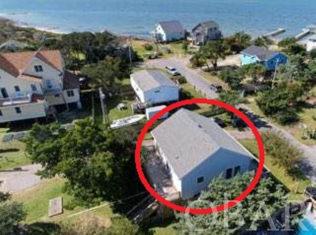 Fall in love with this single-story elevated home. Large, sunny front & back decks to enjoy the peaceful Pamlico Sound views & breezes (imagine the views if you were add a roof-top deck!) It’s located on Lighthouse Rd, not far from the Ocracoke Lighthouse, and a short walk or bike ride to Springer’s Point Nature Preserve & Silver Lake Harbor.  The interior of this newly painted 2 bedroom + den/2bath home has high ceilings, central Heat/AC, and crown molding. LVP flooring installed October, 2023. Both bedrooms have en-suite bathrooms with sliding door access to an exterior deck. Under the home there is covered parking on the concrete pad along with ground-level storage perfect for bicycles, kayaks, beach & fishing gear. This is a sought-after location for both year-round homes and vacation rentals. The home is now empty- the photos with the furniture were taken when a rental, before the furnishings were removed (they were added to  give an idea of furniture layout and spacing.)