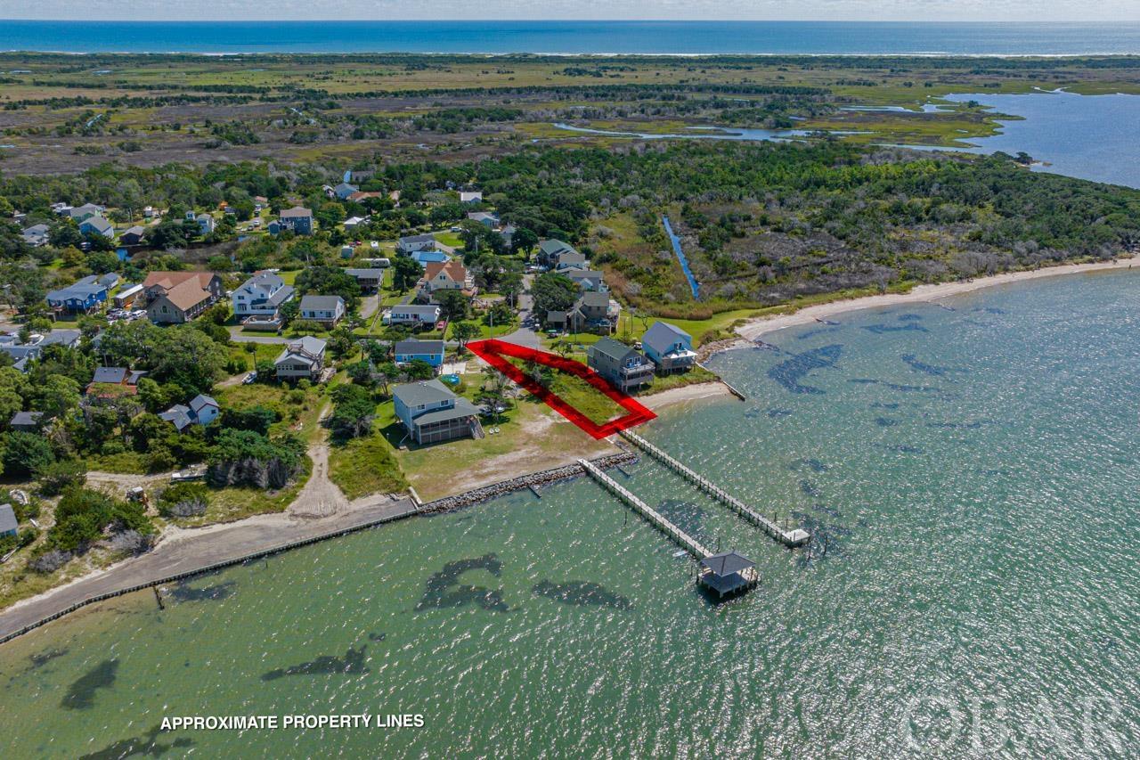 Don't miss this once-in-a-lifetime opportunity to own a prime soundfront lot on Ocracoke Island. This exceptional parcel boasts unbeatable views and jaw-dropping sunsets year-round, right from your future doorstep. Nestled just steps away from Springer's Point, a revered nature preserve, you can enjoy leisurely walks through nature trails that lead you to a sandy beach overlooking Teach's Hole—the fateful location where pirate Blackbeard met his end. Adding to the allure is the lot's proximity to the iconic Ocracoke Lighthouse, injecting a dose of rich history and local charm into your daily life. Building your dream home here is easier than ever, as this lot comes complete with a three-bedroom septic permit and an approved site plan, with a paid water impact fee, ready for construction. Located just a short golf cart ride away from the island's finest amenities, whether you’re interested in accessible deep water boat docking, waterside dining with friends, or immersing yourself in an island lifestyle rich with culture and history, Ocracoke has it all. Don’t wait; this is a magical opportunity to own more than just land—it’s a chance to own a lifestyle. Call me today to secure your future haven on Ocracoke Island.