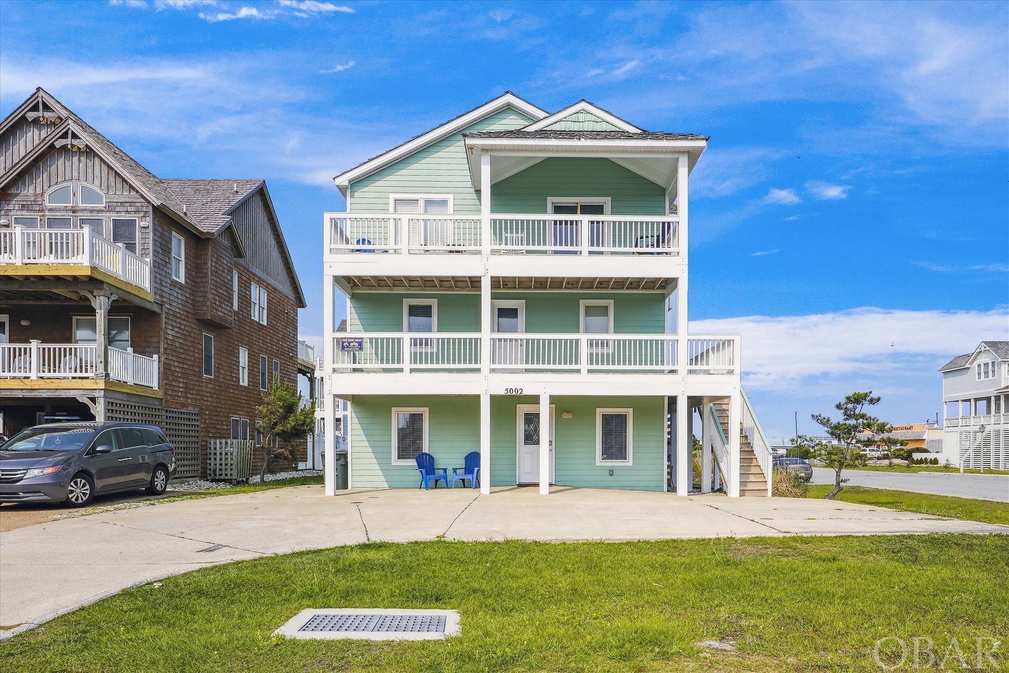 Beautiful 7 bedroom, five and 1/2 bath semi-oceanfront home located on a corner lot at E. Mall Dr. and the Beach Road in the Village of Nags Head.  Has all the amenities such as an elevator, pool, hot tub, game room, and lots of decking with ocean views to make this a great rental home or your dream home.  The top level has a primary suite, four bedrooms on the mid-level and two additional bedrooms on the ground level.  Lots of improvements in 2023 - outside house painted, new furniture, new bedspreads, lamps, hardwood floors and steps refinished, all new appliances (except washer and dryer) and more.  New elevator installed in 2022.  The Village of Nags Head offers a shuttle bus, 2 Sound accesses, ocean access with parking and a bath house less than 500 feet away.