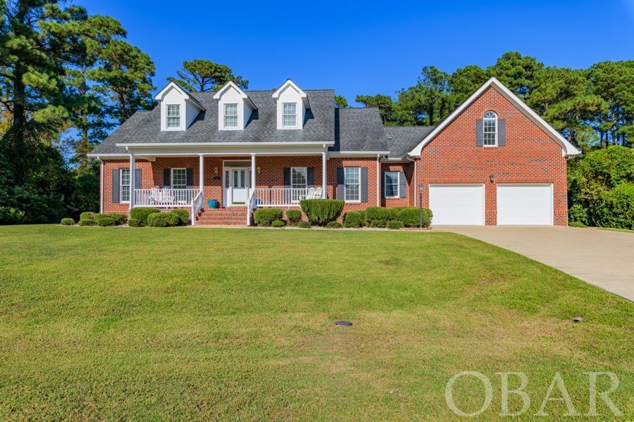 An absolute stunning, well maintained home in the heart of the highly desirably Mother Vineyard neighborhood. Walking distance to schools, downtown Manteo, & the bike path leading to the Lost Colony & Elizabethan Gardens.  This beautiful brick home sits high on an elevated lot which has been landscaped and well kept. You can get out of the car on the concrete driveway to enjoy some fresh air or pull into the large two car attached garage to stay out of the elements with the dry entry. The two car garage has hanging shelfs for plenty of storage as well. When entering the home the hardwood floors and open foyer let you know you are home.  The spacious living area with vaulted ceilings and gas logs invite you to sit down and relax, watch a ball game or enjoy the company others. The living area and kitchen are open concept & make this home perfect for entertaining friends and family.  The hardwood flooring continues through the bottom floor into the well equipped kitchen, which is open to the breakfast nook to be able to catch up on the days events with family or eat in the kitchen. Right off of the kitchen is the formal dining room to host friends and family alike.  The master bedroom features hardwood floors, vaulted ceilings and crown molding as well as a spacious walk in closet and ensuite bathroom with a double vanity.  Also on the first level there are two guest bedrooms and a guest bathroom with tub/shower, a half bath, and laundry area.  Moving upstairs you feel the warmth of carpeted flooring, a large bonus space perfect for a playroom for the kids with a spare room off the side that could be a bonus kid's room.  This space could also be used as a second living area and office.  There are two large attic storage areas for all the Christmas decor & all items that need extra storage space.   The beautiful, landscaped backyard features a spacious back porch with composite decking ready to host a cookout during those Summer evenings and large landscaped grass area inviting pets, young or the young at heart. A roughly 12x20 utility shed in the backyard helps hold the yard tools and keep the garage clear of clutter.  This home will not last long.