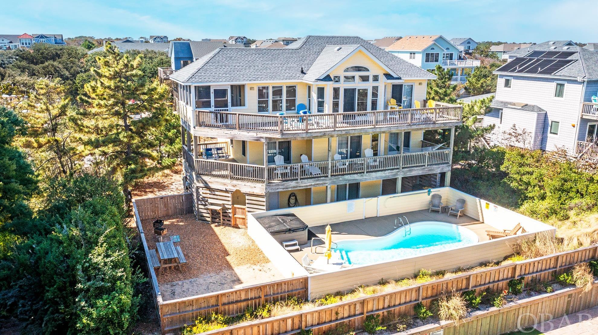 Welcome to Seaduction! Ocean views and easy beach access is what helps make this location so desirable.  The reverse floor plan is designed to entertain. Ground floor has a bathroom, bedroom and the game room with pool table and entertainment all with easy access to the 14x30 pool and hot tub.  Don't forget the added fenced in area for children to play and picnic. The midlevel harbors most of the bedrooms with awesome decor that feeds the beach vacation feel! Deck with hammock and chairs to relax overlooking the pool area. Top floor with cathedral ceilings has open kitchen area with dining that opens to the screened in deck to expand the eating area. Living area with the open feel from all of the natural light glowing through the windows. Seaduction is the home to repeat renters each year!  Excellent care has been provided to this fun vacation home. Come See!