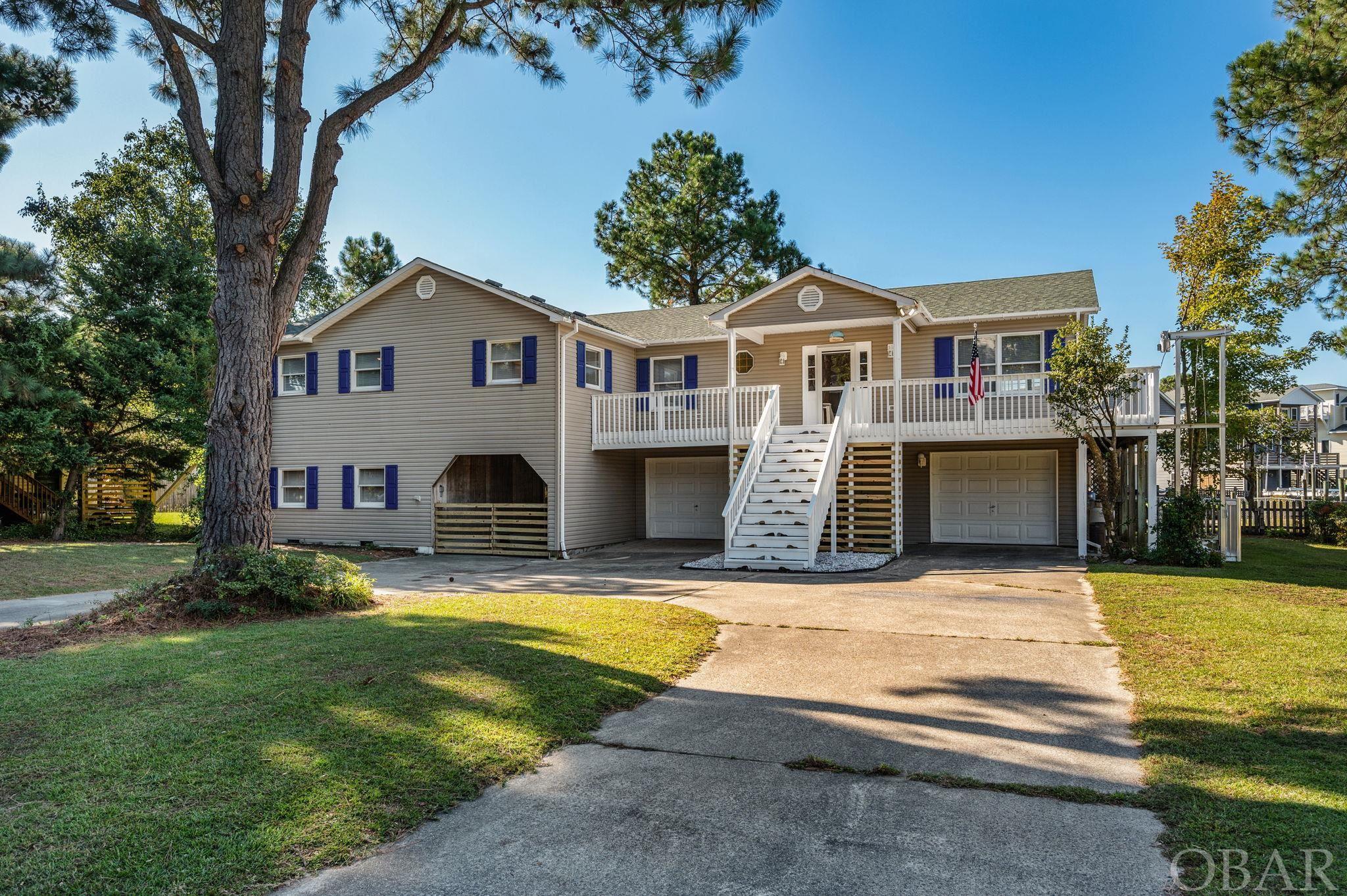 Wow, if you are looking for space this is the one for you!  As you walk in you are greeted with a wall of windows overlooking the canal and Albemarle sound.  The generous 23x23 living room with its cozy fireplace, beckons you to unwind while gazing at the serene waterfront setting. The kitchen has been thoughtfully designed as a place to gather and create culinary memories. The multiple decks and spacious screened in porch provide true year-round enjoyment. The bedrooms are roomy, 2 with en-suite baths. Two fully enclosed sunrooms can double as sleeping porches or offices, so the options are endless and there is plenty of room for everyone to spread out! The backyard invites you to enjoy outdoor gatherings at the waters edge and a tandem carport has room to store the boat. The extra space on the ground floor has endless possibilities! The original house size was doubled in 1995, utilizing the second lot. It has been lovingly maintained including new roof & septic in 2019. So many extras to enjoy also, including and external 1,000 lb cargo lift, EV charger, boat lift, and huge 3 bay garage/workshop along with multiple storage rooms & kayak racks. Listed square foot is for the 2nd floor finished space only.  Floor plans available in docs. This charming home is a rare gem, a perfect haven for those seeking both character and space in a Sound-front Community.  Pool, Yacht Club & Tennis are available for separate joining fee. Deep water navigable canals, summer sailing regattas, kayaking, crabbing, fishing and so much more to explore. Come see & enjoy!