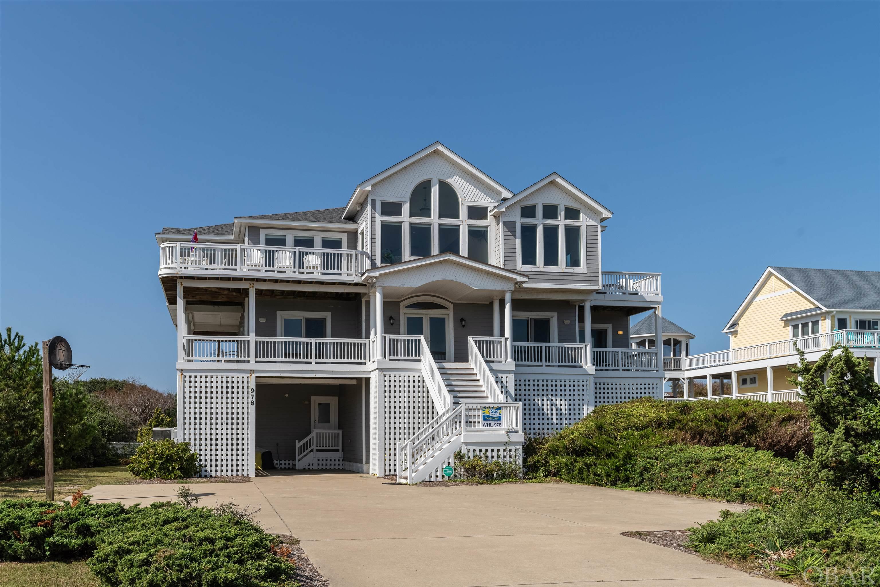 Stunning 10 bedroom estate situated on a spacious semi-oceanfront parcel, just steps to the beach in the heart of the Whalehead Community of Corolla. Boasting panoramic views of the ocean and a countless home amenity package, this is a home you don't want to miss! An open concept living room with large picture windows, a gas fireplace, wraparound sofa, and east facing decks serves as the perfect space to relax and take in the beautiful ocean view. A thoughtfully designed kitchen with stainless steel appliances and countertop seating, dual appliances, a wine fridge, as well as two dining areas, provide plenty of seating and room to prepare for family meals. Step out onto the top level sun deck to watch the sun rise over the Atlantic or to enjoy an afternoon cocktail at the high rise dining table. A half bath, king en suite with private bath, private balcony and fireplace, in addition to a king en suite with private bath (accessed from deck only) complete this top level of living. Relax and unwind after time spent soaking up the sun on the mid level which includes 4 king en suites with private baths (2 with deck access), a queen en suite with a private bath and deck access, an office/study, queen sleeper sofa, half bath, and covered decks. Make your way downstairs for more entertainment where you'll find the rec room with pool table, card table, and a kitchenette with full sized refrigerator, microwave, and dishwasher, in addition to a theater room, arcade area perfect for kids, queen en suite with private bath, two pyramid bunk bedrooms with trundle beds, a full shared bath, and half bath. Step outside to the private pool area with hot tub, half bath, covered cabana bar, outdoor shower, and spacious fenced and landscaped backyard. Enjoy the convenience of a full-sized laundry room with storage, an elevator to all levels, community beach access just 350 feet away, and local shops & dining within walking or biking distance! It's no surprise that this is a sought after home to vacation with friends, family, and guests alike each year!