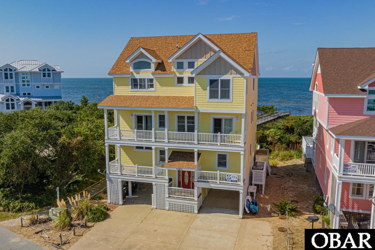 Welcome to your island paradise, Bay Breeze! This soundfront haven offers more than just a retreat; it's an investment in the life you've always dreamed of. In 2023 alone, Bay Breeze achieved a remarkable rental income of $141,646, showcasing its incredible potential. Step onto the boardwalk with private access to a sandy soundfront beach, perfect for windsurfers, kiteboarders and endless water adventures. Relax and unwind on three levels of decks, where spectacular sunsets paint the sky with vibrant hues, transforming your vacation home into a masterpiece of coastal living. Your personal oasis awaits with a refreshing pool and a fenced-in pool deck, as well as a bubbling hot tub on the first-level covered deck. Inside, the entertainment options are endless, from challenging the family to a pool tournament to enjoying a movie in the media room. For those seeking a cinematic escape, the theater room boasts comfortable seating and a projection screen TV, creating the perfect ambiance for movie nights. Two bedrooms on this level cater to the younger members of the family, with a master bunk room featuring two twin-over-twin bunks and an attached private bath, as well as a bedroom with two twin beds using the hall bath. Move seamlessly between levels using the elevator. The second level showcases four master bedrooms, each with private baths, deck access, and breathtaking island views. Two of these bedrooms, one king and one queen master, offer unparalleled vistas of the sound, making them perfect spots to greet the day with the beauty of sunrise. The other two bedrooms, both queen masters, open up to stunning sound views, allowing you to step outside in the morning and witness the island's sky painted in shades of pink by the sunrise. A sitting area on this level boasts large deck doors, inviting you to relax indoors while enjoying the sound view. The open-style kitchen is a chef's dream, equipped with a glass-top stove, double oven, ice maker, and a kitchen island with additional seating. Enjoy quick bites at the island or gather around the dining table that accommodates eight. Clean-up is a breeze with a deep sink and two dishwashers. A sunroom off the great room provides a delightful space for card games, additional dining, or simply savoring the sound views. Stock the adjacent wet bar, complete with a wine fridge and sink, for added convenience. Retreat to the seventh bedroom, a king en-suite with an attached private bath and a jacuzzi tub, for a peaceful evening on the deck. Watch the famous Hatteras Island sunsets from your private sanctuary, creating a nightly ritual to cherish. Bay Breeze is part of the esteemed Kinnakeet Shores community, granting you access to the community pool, tennis courts, and beach access. Your island retreat awaits.