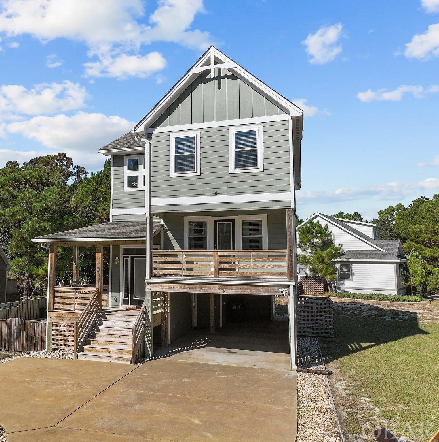 Enjoy a slice of Outer Banks heaven. This four bedroom, 3.5 bath home was professionally designed by Florez and constructed by local, Accredited Master Builder, Forrest Seal. Perfectly located, this home offers a quiet cul-de-sac setting while only being minutes from all of the Corolla attractions. With two main suites, a game room with a wet bar and half bath, this home has must-see features: an open great room and kitchen with solid honey oak flooring; Navejo white granite countertops, cherry stain wood cabinets, and SS appliances. The bathrooms have granite countertops. The exterior has architectural shingles, smart siding, and vinyl windows. The carport accommodates two cars. Newly installed (this Spring) gutters in front and back. There are multiple covered sun decks with basket weave lattice work that offers privacy. The community has all of the amenities: multiple piers over the sound, clubhouse, pool, gym, tennis court, playground, and boat launching ramp. Only a short walk or bike ride to the beach, this house works as a second home, a primary residence or a vacation rental.