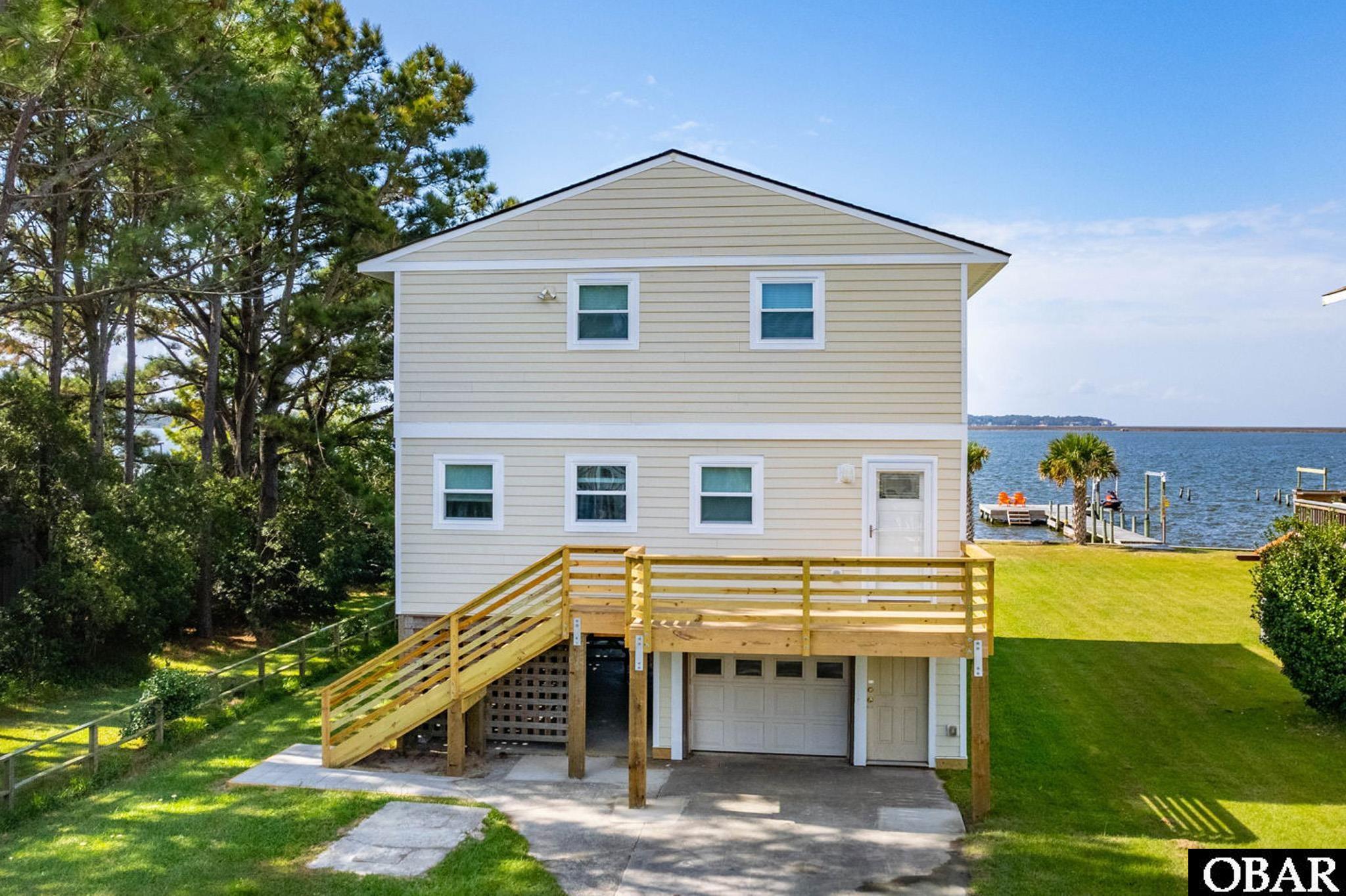 Take this opportunity to own an amazing sound-front home on Bay Drive with gorgeous water views from every level!  Here on the Outer Banks, sound-front homes in KDH are known for their amazing sunsets, and this home is no exception!  The multi-level decking grants water-front deck access from each level of the home and a completely cleared lot allows for an abundance of landscaping potential!  The water side of this home has also been bulkheaded to protect from erosion and talk to your agent about potential for installing a pier!   This Bay Drive, Sound-Front home was in a rental program for many years, but also has plenty of appeal as a permanent residence!  With a great room on the top floor, allowing for panoramic water views from all angles, to an additional mid-level living room with immediate water-side deck access, this home offers an abundance of living space and potential!  This prime KDH location places this home within minutes to the beach, as well as to restaurants, shopping, grocery stores, golf (including miniature golf), a cineplex, and so much more!  The home is also near the Bay Drive boat loading area, making this home a perfect candidate for the seafarer in your family.