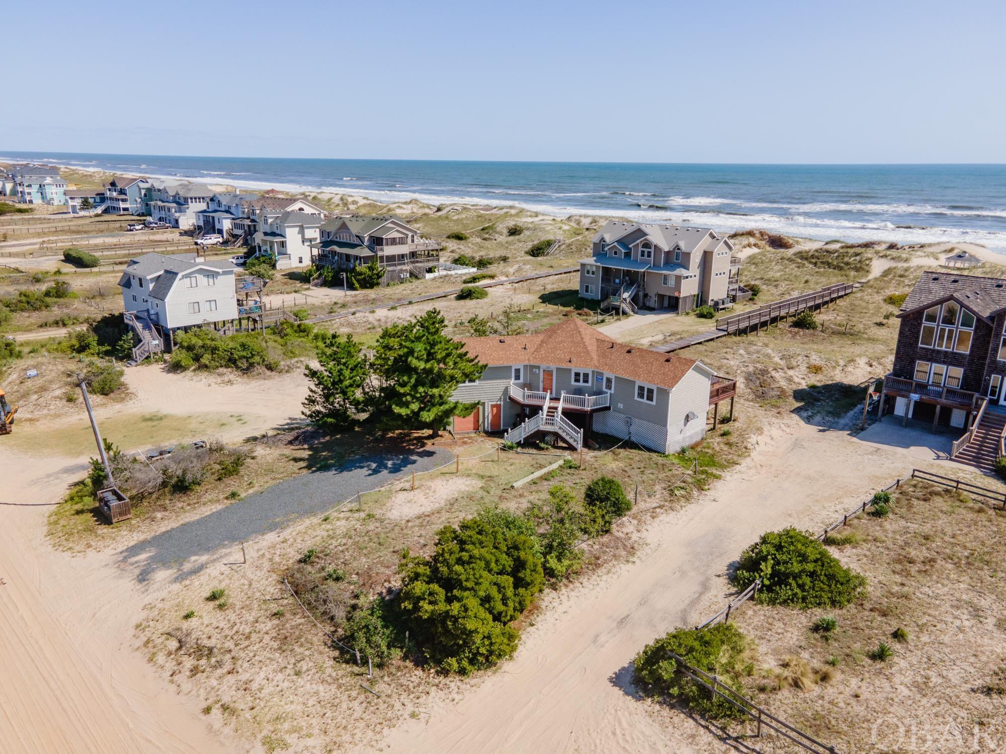 Beautiful oceanfront cottage located in the heart of Carova Beach.  This home is turn key and ready to go with huge upgrades including, but not limited to new siding(2017), fortified roof(2022), new septic drainfields(2022), all new plumbing(2023).  There are so many possibilities whether it be a 2nd home or investment property, with a rental projection of $91,285 for 2024!  This three bedroom home is located in an X-Flood Zone, which means no flood insurance is required.  As you walk in, you are greeted with a cozy open floor plan great room and kitchen area with cathedral ceilings and tongue and groove walls that give you that classic Outer Banks beach cottage feel.  The south bedroom is ensuite and has its own slider leading out to the oceanside deck and hot tub area.  The north wing of the house has the two remaining bedrooms currently set up as a king room and a bunk room.  There is an attached garage that is great for owner storage or has the potential to be turned into a small rec room.  Underneath the house has a concrete slab and makes for a perfect shaded gathering spot during the summer.  Everything flows smoothly to the elevated beach walk to the dune which gives easy access to the beach.  Schedule your showing today and don't miss your chance to own an affordable yet quality oceanfront beach house.
