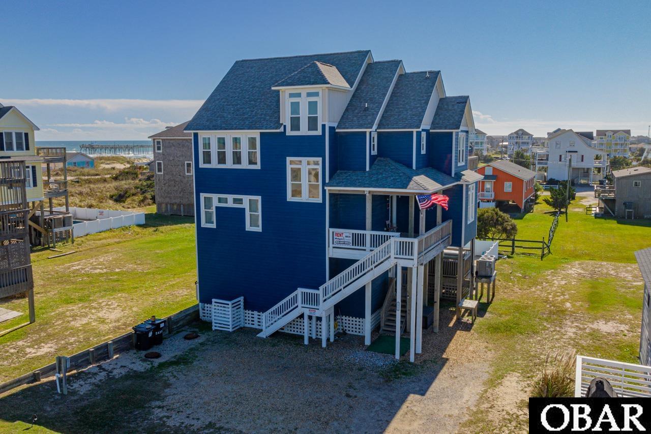 Embrace coastal luxury with this six-bedroom, five-and-a-half-bathroom home, perfectly positioned just four lots from the oceanfront and offering striking views of both the ocean and the sound. Experience the beauty of every sunrise and sunset from the expansive sundeck of this three-level haven. Upon entering the first floor, discover a queen bedroom and a second bedroom featuring a pyramid bunk set with trundle, sharing a well-appointed full bathroom. The vibrant game room is an entertainment paradise with a ping pong table, Ms. PacMan arcade game, a wet bar, full-size refrigerator, and microwave, all leading to a shaded deck with a hot tub overlooking the private pool. The second level is home to three sizeable ensuite bedrooms, two with king beds and one opening onto a shaded ocean view deck, and the third boasting two pyramid bunk sets. Convenience is key with a laundry area situated between the first and second floors. The top level is the crown jewel with an additional king ensuite bedroom, complete with a Jacuzzi tub for the ultimate relaxation, complemented by panoramic ocean views from the open-plan living, dining, and kitchen area. This level also features a quaint lofted nook, perfect for enjoying the horizon, and a handy half bathroom. Outdoors, the private pool and wide deck await for sunbathing and social gatherings, with the beach and Rodanthe Fishing Pier only a short walk away. The area is a hub for exciting activities such as fishing, surfing, and kiteboarding, with convenient access to water sports equipment rentals, shops, and restaurants. "Come Sail Away" is not just a home; it's a lifestyle choice for those seeking island adventures or simply a peaceful escape. Even with a limited calendar,  rental income is over $74K; with an open calendar  potential rental income of over $100K (See Associated Docs for projections).  Already over $38K in rental income for 2024!  Seize the opportunity to make this Rodanthe gem your permanent residence, where life is perpetually a beach vacation. To explore this unique property and secure your piece of paradise, schedule your viewing today.