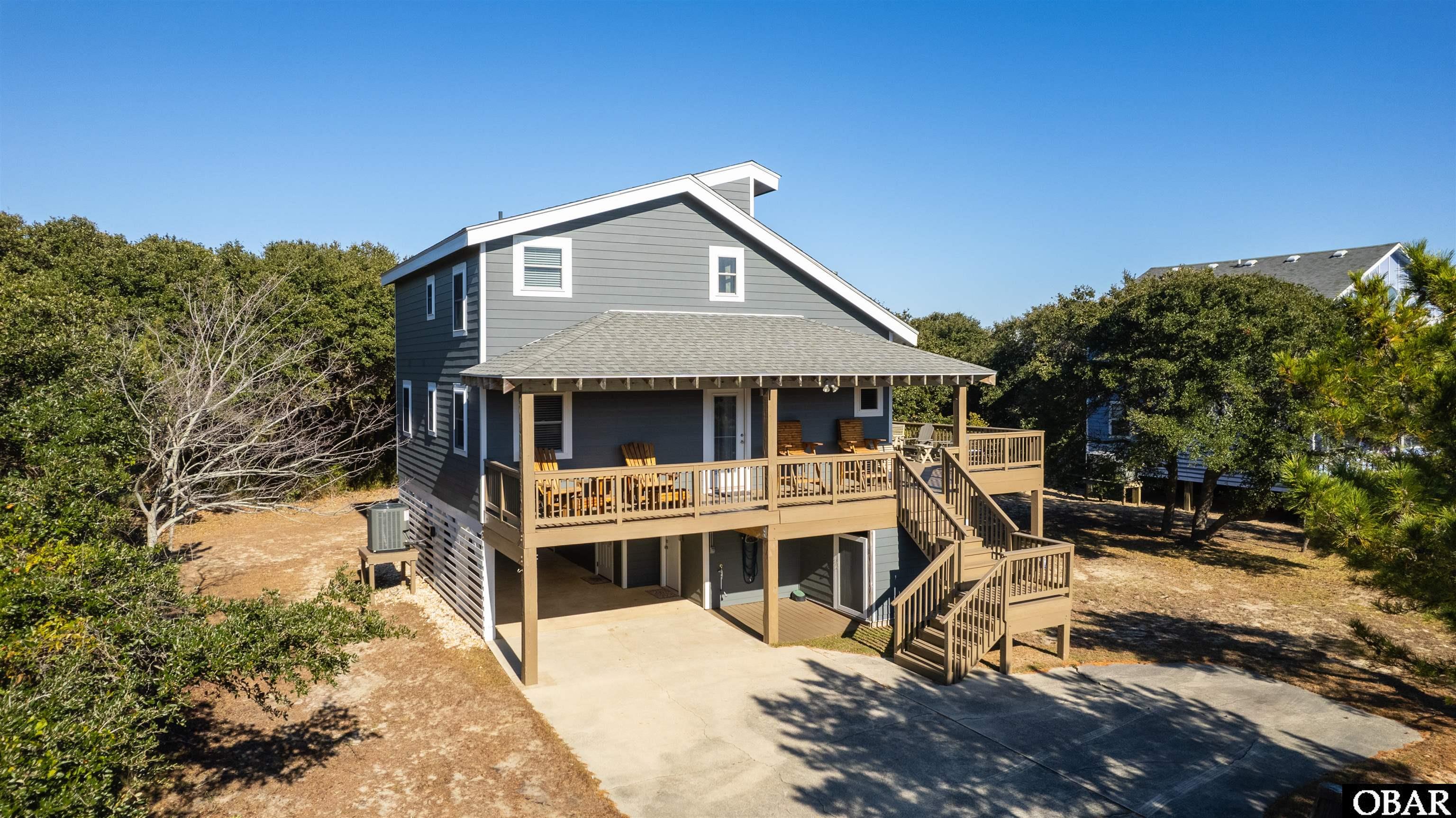 Located just a short walk from neighborhood beach access, this beautiful home is turn-key ready as a second home or a rental property.  Completely renovated (interior and exterior) in 2013, this home features beautiful living space with lots of natural light. New interior paint (2020), new exterior paint (2022), new HVAC system (2023), newly stained decking (2023), as well as a completely new fortified roof (2019) are just a few of the features of this excellent condition house. Wood burning fireplace, lower level full on-suite guest space and a large yard are also featured. Owned by the same family since 1998, this beach house has been used as a second home, not a rental property, since 2013. This home is situated on a large lot.  Preliminary investigation looks positive for a swimming pool or other backyard features.  Thirteenth Avenue has a streetlight for easy access during summer months, and is a short walk from the town of Duck, both it's shops and restaurants, and the beach, which is dog friendly.