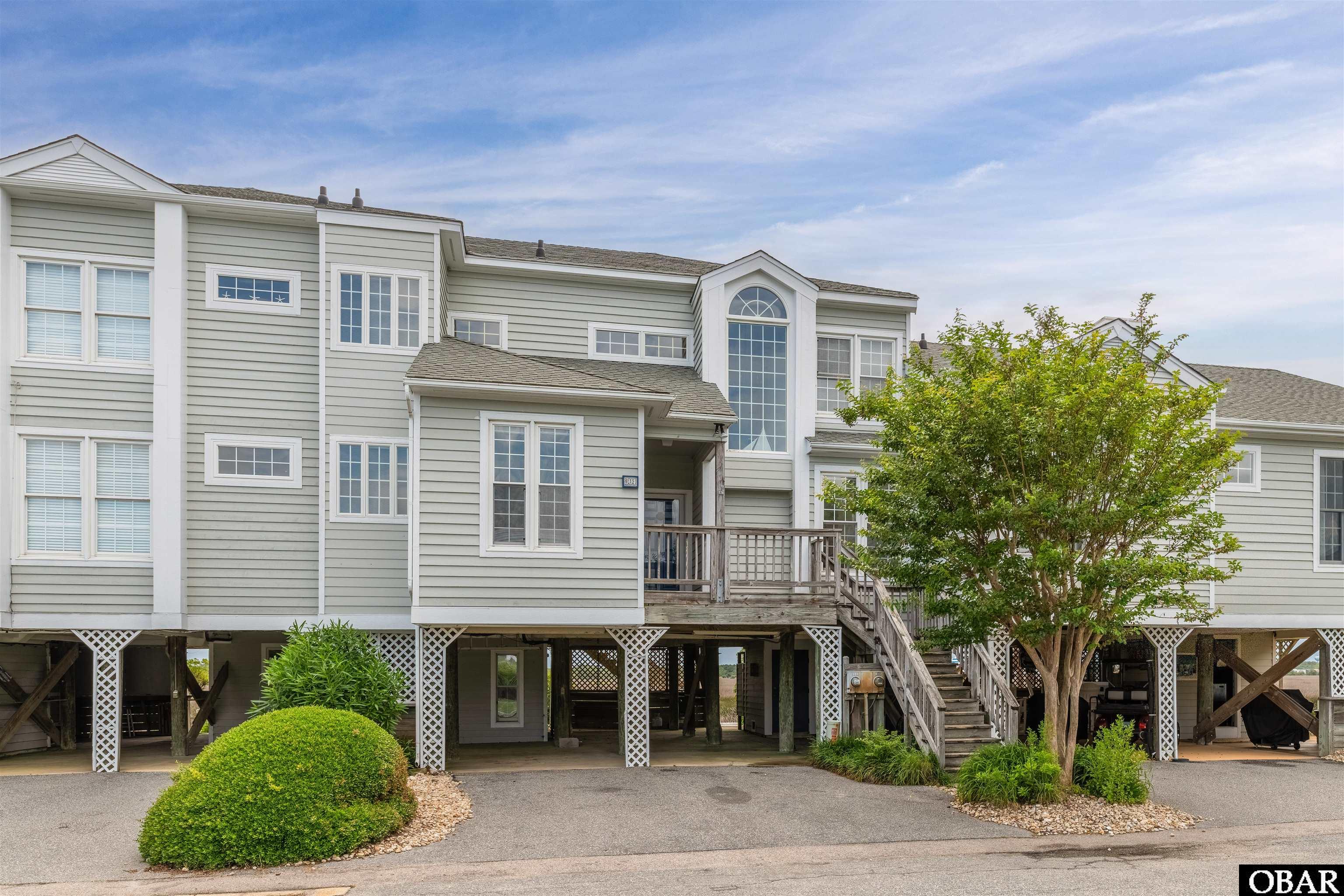 Welcome to your dream CANALFRONT townhome with assignable BOAT SLIP! This stunning property offers 3 bedrooms, 3 baths, and the perfect blend of luxury, comfort, and waterfront living. With its prime location right on the canal, you'll enjoy breathtaking views and direct access to Manteo Bay.  Inside you'll be greeted by a spacious open-living concept on the first floor. The living area boosts large windows that flood the space with natural light. Imagine waking up with the canalfront views and sipping your morning coffee on your private covered deck. On the first level you will find ample room for entertaining as well as a guest bedroom, guest bath and a master bedroom with ensuite bath. Up the stairs to the second level loft area you will find space for an office, crafting area or as it is now more sleeping room. Open to below, as you walk into the second master bedroom featuring an ensuite bath as well as your very own private covered deck on this floor, which is sure to offer amazing sunsets and soundviews.  Located in the highly sought after community of Pirate's Cove, this canalfront townhome offers the best of both worlds - a serene retreat away from the hustle and bustle, yet only 10 minutes to shops, restaurants, and the ocean.   Fully Furnished to inlcude the brand new sauna and golf cart (used). Pirate's Cove is home to Bluewater Raw Bar and Grille and Pirate's Cove Marina where you'll find world class fishing charters. Amenities included 2 pools, tennis courts, clubhouse, fitness room, playground, golfcart friendly, security, and sound access.   Boatslip directly behind the unit assignable by PCHOA.
