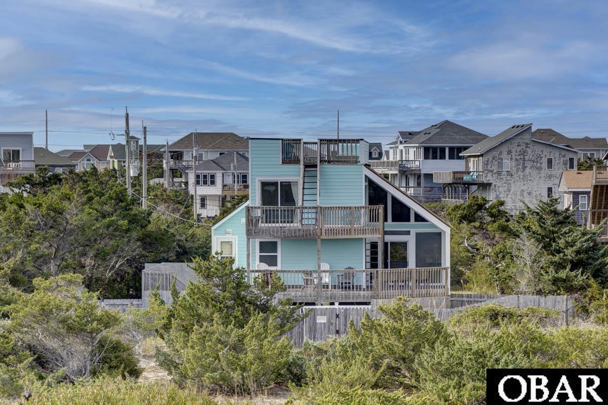 "Family Affair" has a great ocean front location in Hatteras Colony in Salvo, NC. Many improvements have been made in the past four years including the addition of a swimming pool and fence, new siding, pilings, roof, septic, heat pump, flooring and other updates. This beach house doesn't require you to climb lots of stairs since the main living area, kitchen, dining, laundry room, and a primary bedroom and bath are on the first level, with two additional bedrooms and a bath on the top floor. The contemporary design with a wall of windows allows abundant sunshine in the vaulted living room. There's a good amount of decking on the ocean side with a roof top deck the length of the whole house where you can enjoy the sunrise over the ocean and catch the sunsets over the sound. The house has been rented through VRBO and allows the new owner to continue renting by owner, place it with a local property manager, or occupy as your full or part-time beach home.