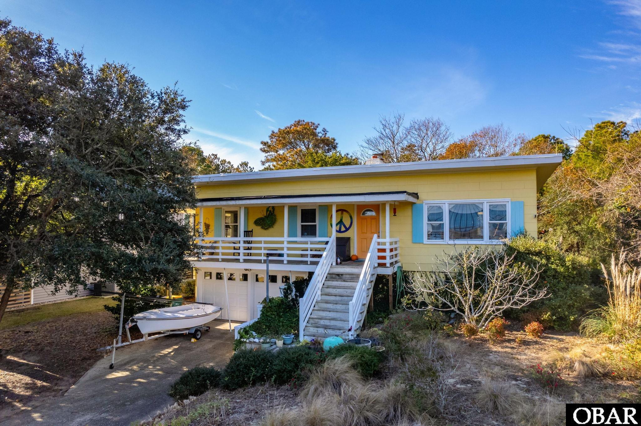 Don’t miss the rare opportunity to own a vintage Southern Shores flat top in a perfect location close to the beach! This beauty from 1960 is airy and light with a fantastic 3/2 floor plan plus incredible basement storage (including a half bath) and a double garage. Don’t worry—its not a tear down! It is a great primary home, second home or vacation rental property.  Inside the home the large windows and skylights bathe the living room area in natural light. The wood paneled walls are epic. The kitchen is designed and outfitted by a chef. There are cool nooks and crannies offering storage and style. The tiled baths are updated with modern touches and timeless materials. The 5 panel cedar doors throughout are gorgeous. The wood burning fireplace is solid and substantial.     The location could not be more ideal.  It is perched at the top of the dune with great elevation. Stroll just 500 yards to the beach directly down Skyline, or you can also take the Ocean View Loop trail to get to a roll over access. The home backs to Chickahauk common space for added privacy. It is steps away from the path connecting to an incredible network of sidewalks and shaded walking paths.  Skyline is a hidden gem in Southern Shores with 6 historic flat tops, no cut through, smaller lot sizes with smaller homes, all within easy walking distance to great restaurants and shopping.  Its super convenient to everything—the beach, airport, “town”, Duck.  Walk, bike or e-bike everywhere you need to go.  Skyline was the first street developed in Southern Shores and today has a nice mix of primary and second homes with the occasional rental.    If you want a home with style and soul, this is your chance!
