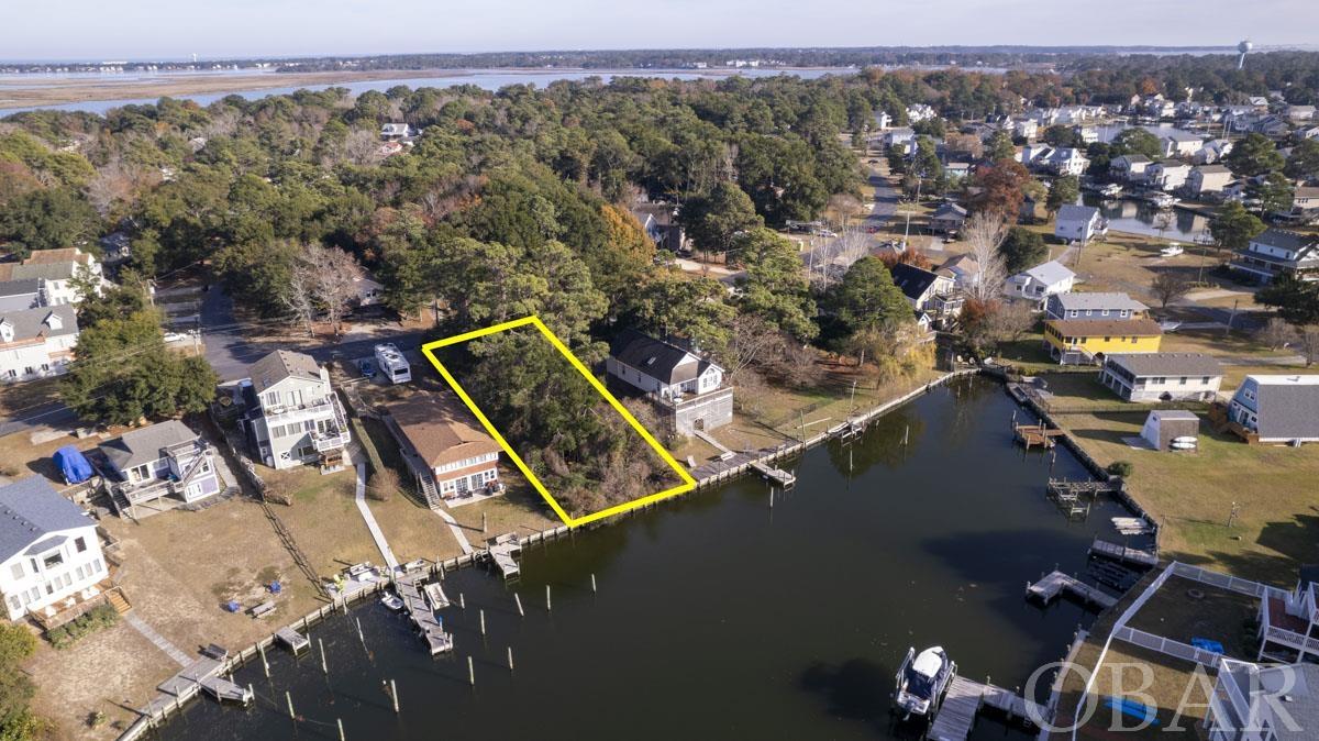 CANALFRONT LOT WITH GREAT VIEWS! Perfcect spot to build that waterfront dream home. Colington Harbour is the most popular waterfront community on the Outer Banks. The community features; gard gate with 24  hr security, easy, deep water access to the Albemarle sound, a beautiful soundfront beach area dotted with century old live oak trees, playground for the little ones, a large boat launch area, basketball court, and of course those amazing Outer Banks sunsets. Also, for a nominal fee owners can join the Colington Harbour Yacht & Racquet club which will give access to olympic size saltwater swimming pool, tennis, and clubhouse. The location of the lot is super, located not far from gate enterance and very short distance to all of those great amenities. The property has 56 ft. on the canal and home built on this site will have very nice views looking down Baggala Inlet looking west towards the mouth of the harbour. Come take alook today!