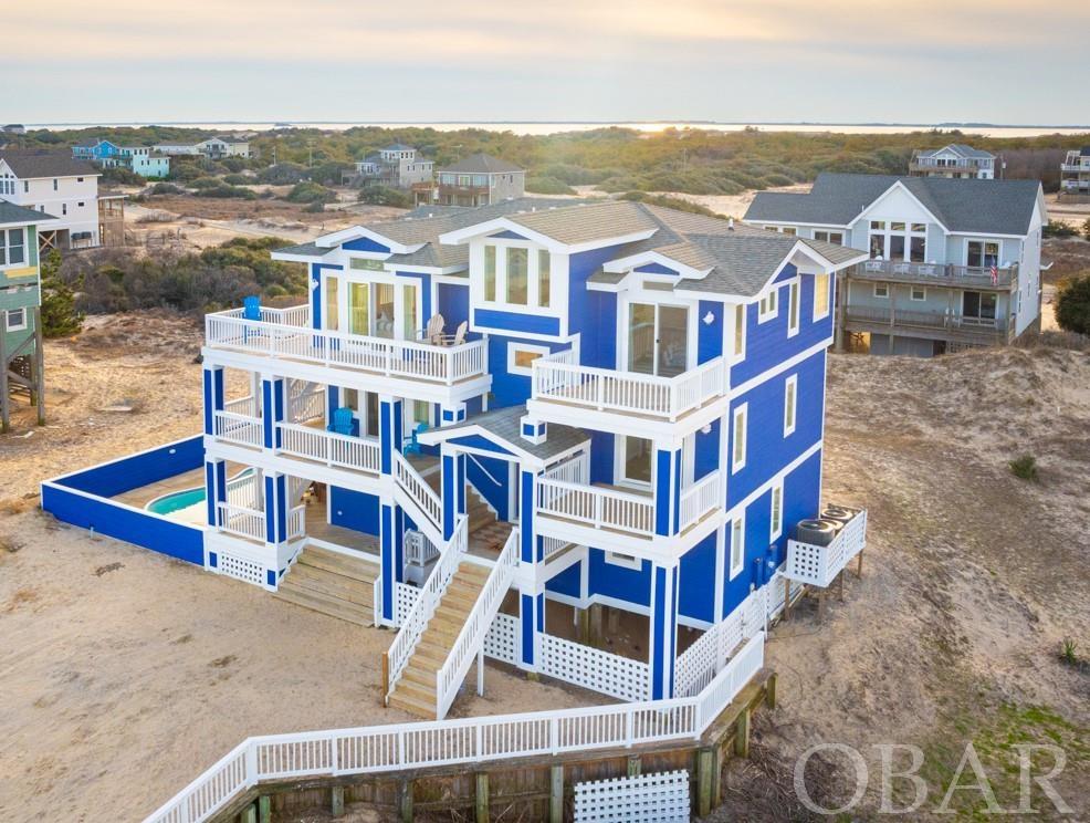The Shore House has booked over $73,000 in its FIRST FOUR WEEKS with the Wander vacation program.  Search Wander Outer Banks to discover.  First two guests rated a perfect 10/10!  Ocean views from all three levels, a very rare find on the Outer Banks! Modern beach home with panoramic views (Ocean and Sound) in Corolla!  "Shore House” is fully remodeled and professionally designed.  The home features ocean views from every level, and five of the six bedrooms. The top level boasts an open floor plan, excellent for gatherings.  The Chef kitchen is entirely brand new.  GE cafe appliances, quartz countertops, oversized island with storage and microwave drawer, and soft close cabinets.  All new furniture throughout featuring high performance fabric.  Shiplap wall with 65" TV, custom mantle and gas fireplace.  Durable LVP flooring throughout the entire home.  The master bedroom has amazing oceanviews, private deck and a luxurious bathroom with soaking tub and floor to ceiling shower tile. My favorite part about the top floor are the views, truly unmatched.  Panoramic ocean views and you can also see the Currituck soundfront!  The mid level consists of four total bedrooms.  Two are large ensuite master bedrooms.  Both of the master bedrooms have great ocean views and walk out decks.  Two bedrooms are connected with a jack and jill full bathroom.  The south facing room with Queen bed has oceanviews with deck access.  All bedrooms have room darkening drapes. All the bathrooms boast new flooring, cabinets, faucets, sinks, mirrors and light fixtures.  Brand new bedding, furniture and decor in every room.  The ground level of the home has a large gameroom, master bedroom with ocean views, laundry room and a half bath with poolside access.  The master bedroom has all new furniture, bedding, and decor.  The most unique item about the room is it has an Oceanview!  Its very rare to find a home that has oceaviews from the ground level.  The gameroom features a large 75" TV, new furniture, pool table, wet bar with new Frigidaire refrigerator.  Additional home upgrades include ALL new slider doors, interior and exterior paint, light fixtures, cabinets, door/cabinet hardware, and HVAC unit.  The exterior has large wrap around decks on two sides of the home.  Plenty of space for enjoying the ocean breeze or watching the Wild Horses!  The home has a large fiberglass in ground pool with ocean views and new outdoor furniture.  The home is currently featured in Wander's vacation rental program.  The high elevation of the property is also a benefit, aside from giving it amazing views.  Located in the lower risk flood x zone that does not require flood insurance.  If you're looking for a professionally designed luxury home, close to the beach with unbelievable views, come see "Shore House".