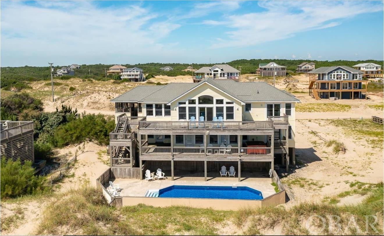 Breathtaking Panoramic Oceanfront views on unique expansive 1 acre oversize lot with 6 bedroom secluded SFH with bonus office/movie room. Huge Great Room with open floor plan to view boasting unparalleled million dollar views. Steps from the ocean, see all the breathtaking sunrises and sunsets from this heavenly oceanfront home.  Drive on the unpaved 4 x 4 path that hugs the ocean to the secluded heavenly abode. Must see Oceanfront Coastal living in North Swan Beach borders to Carova Beach/ City of Corolla NC.  Walk-in pantried kitchen is adorned with blue pearl granite tops and dual European brand dishwasher / European appliances.  Million dollar Oceanfront view from the deck includes living with the Historical Spaniard Mustangs from the 1500's. Fenced in area adds to seclusion vacationing with the Mustangs exclusively. Ranked #1 as the best vacation spot in the world, with the Outer Banks series of 4 seasons thus far. It's on everyone's bucket list to live with the Mustangs for a week/two or three weeks to a month.  Coastal haven has 5 Oceanfront bedrooms with separate private baths and 1 sound view room. Luxurious amenities include a private pool and hot tub for your morning and evening recreational swims.
