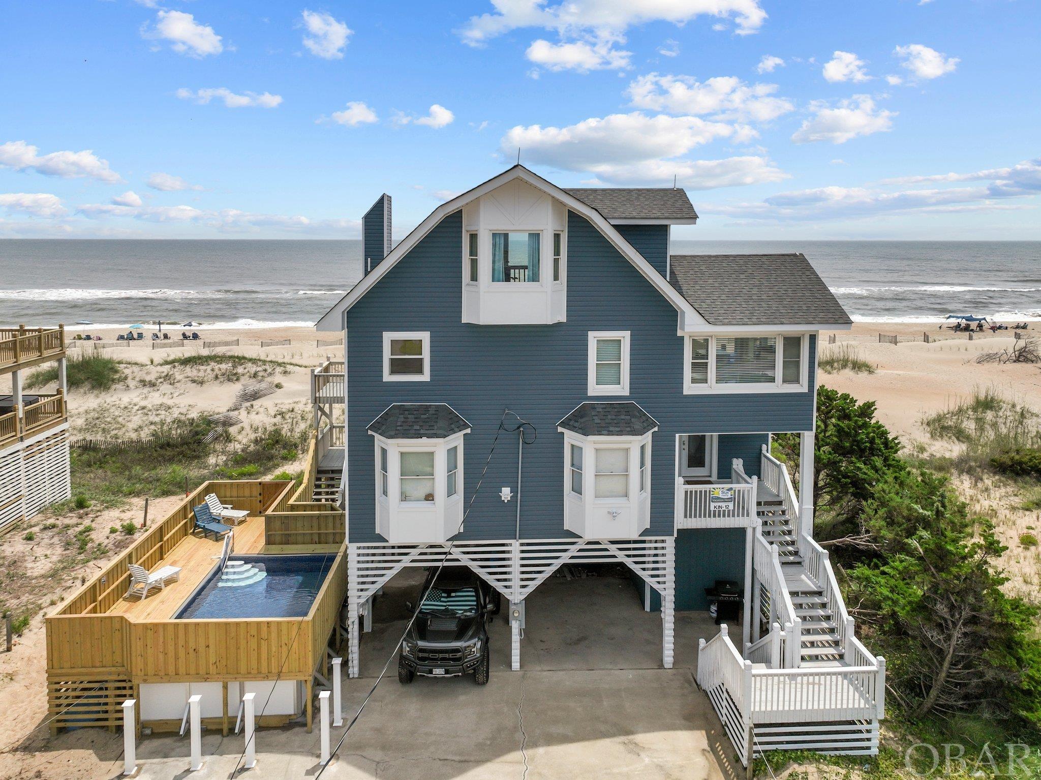 Over $164K YTD for 2024.   $170K for the 2023 rental season.  Over $500k in renovations from top to bottom, with a new private pool, this amazing Oceanfront located centrally on the newly re-nourished beaches of Avon offers incredible panoramic views of both the ocean and even glimpses of the sound.  This makes it one of the few homes where the beauty found outside matches what you experience when walking in.    The beautifully decorated living area with new furnishings and luxury vinyl tile provides plenty of comfortable seating with a large embankment of windows allowing visitors to soak up some of the best views of the Atlantic Ocean while in the comfort of your own home.  The well-equipped kitchen with a breakfast bar, new granite counter tops, stainless steel appliances and 2nd refrigerator provide a setting that can handle light hors d'oeuvres or family-size meals in style   Along with a large dining room table, the home provides an alternative sitting area/den. Sliding doors to the oceanfront deck and large picture windows provide even more stunning ocean views and natural light. Dine al fresco while enjoying the sea breezes at the picnic table on the deck.  The extensive updates continue as one visits the more private areas of the house.  More luxury vinyl tile, new bedroom furnishings, paint and custom tile showers makes it clear, no expense was spared in the renovation.  The mid-level offers a king bedroom, 2 queen bedrooms, and a bedroom with 3 twin beds along with the two aforementioned renovated bathrooms.  Upstairs a captains cove loft with full bath and more impressive views from the highest vantage point of the house.  Outside, both sun and covered decks are accessible from most bedrooms and living areas, all with more of those stunning views.  The mid-level shaded deck even features a brand new hot tub.    On the lowest level, you will find the newest update, a custom 12x21 foot pool.  Come and see for yourself, a top of the line oceanfront, in an X flood zone brimming with rental potential for 2023 and beyond.   In fact, with $185K on the books for 2023, all while not being rented for spring due to renovations, Sun Realty is projecting almost $200K with a full open calendar.  Taking a huge step forward, the home currently has $176K in prebookings for 2024 setting the stage for a monster year next season.   See below for over $500K worth of updates to the property.  • New Roof • New siding • New exterior window trims • New facia boards  • New Windows, trims and exterior doors • New framing and walls on the ocean side • New top level deck • New hot tub • New heated swimming pool with a privacy fence • Window treatments • Landscaping  • New Paint • New contemporary light fixtures/Ceiling fans with remote control • New large screen Roku TVs on each room • New furniture throughout • New decor