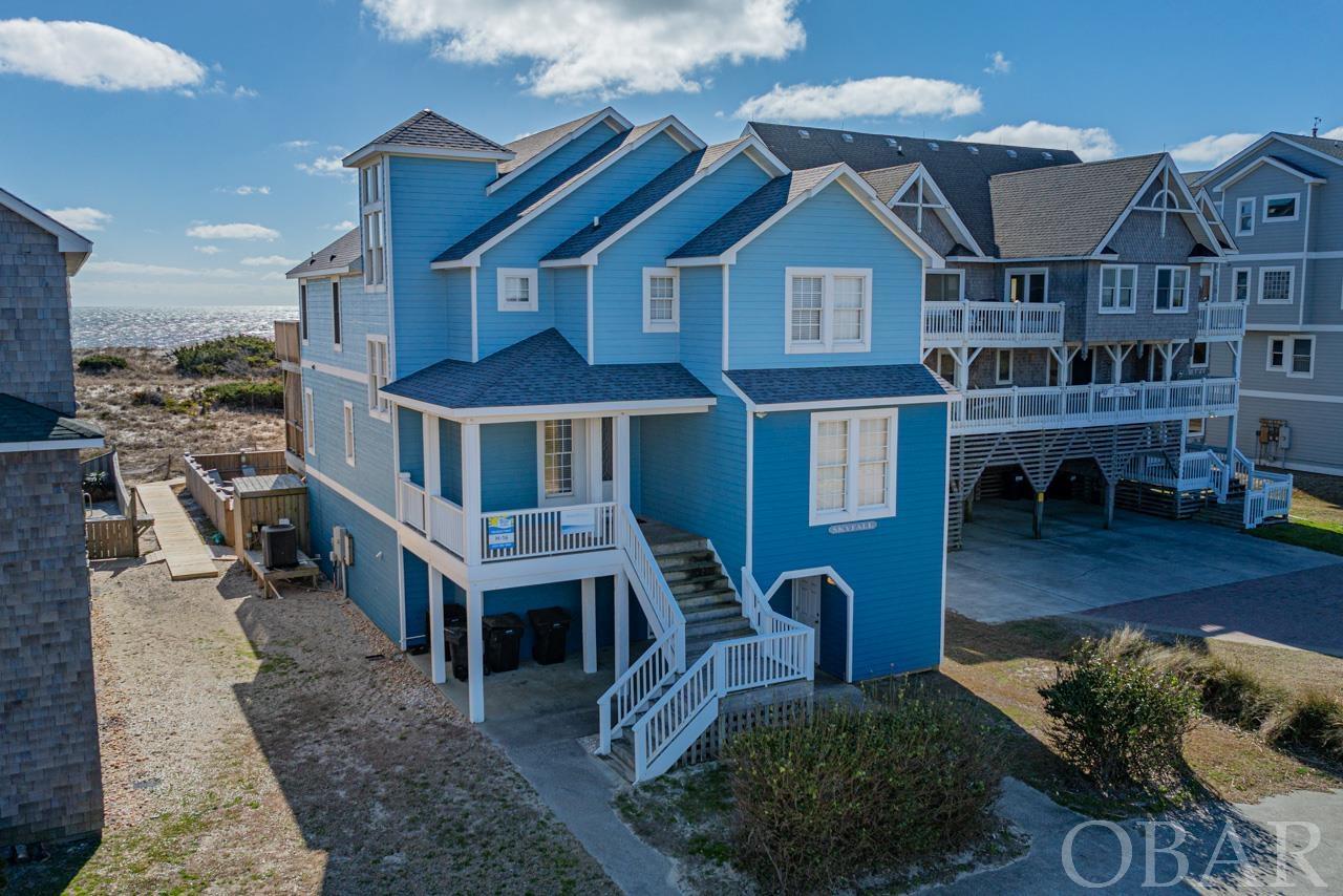 Welcome to "SkyFall," an exquisite luxury oceanfront residence that epitomizes dreamlike living. Extensively remodeled in 2018, this stunning home features new siding, a new pool, roof, paint, hot tub, and high-end furnishings, among other upgrades. Not only does it offer expansive, unobstructed views of the ocean, but it also boasts an impressive rental income of $239,000 in 2023 and already $215,000 on the books for 2024. The serene location allows the soothing sound of ocean waves to lull you to sleep and provides a perfect spot for dolphin watching during your morning coffee. The property includes a large, private pool and a spacious hot tub, complemented by a covered porch ideal for entertaining and an outdoor shower for added convenience. The first floor is a haven of fun with a vintage baseball-themed game room equipped with a pool table, wet bar, kitchenette, and a home theater featuring a 90" TV with cinema surround sound. Accommodation on this level includes two King Bedrooms and a bunkbed room with six twin bunks. The second floor houses three King bedrooms, each with its own en suite bathroom, a Queen over Queen bunk room, and an additional room that doubles as a lounge area with a flat-screen TV, also accommodating three with a twin bed and trundle. The top floor is the crown jewel, featuring an impressive great room, a gourmet kitchen with stainless steel appliances, granite countertops, custom cabinets, and a breakfast bar. This floor also includes an en-suite king bedroom. SkyFall's location ensures privacy while still being conveniently close to shops, restaurants, charter fishing, and the charming local Hatteras Island Villages. The area is golf cart street legal, offering a unique and charming way to explore the surroundings. This home is more than just a residence; it's a luxury retreat offering both personal enjoyment and an excellent opportunity as a rental property.