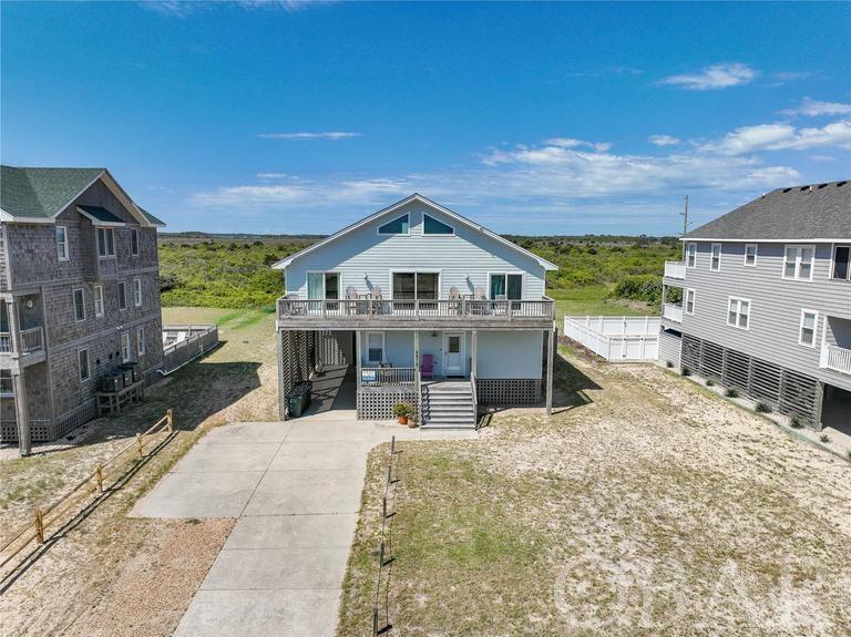 Look no further! This classic seven-bedroom beach house in South Nags Head is ready for the 2024 rental season and is awaiting new owners. The home has been completely updated with quality coastal décor and furnishings, and offers multiple levels with plenty of room for large groups to spread out. It has everything you’ll need to make fun memories of the Outer Banks. The ground level offers a large recreation room with full size refrigerator (and icemaker), a wet bar, pool table and second living area, along with two spacious bedrooms with a connecting Jack n' Jill bathroom, and a laundry closet with stackable washer and dryer. It also offers direct access to a covered deck and HUGE (30’x15’) outdoor fenced-in concrete pool area. With beamed ceilings and stunning ocean views the large open living/dining area on the middle level boasts a well-equipped kitchen with stainless steel appliances, a breakfast bar, pantry, half bath, and there is access to the front sun deck. On this level are five bedrooms, two on one side of the home, one having its own private bathroom, deck access and ocean views, and three on the other, all sharing the hallway bathroom. On the top level you’ll find a third lounge area with games table, two more sofas and gorgeous views of the sound and Cape Hatteras National Seashore Park. The location of this home is ideal, as it’s just steps away from the Ida Street Beach Access (300 feet), and within walking distance of the lively hangout Fish Heads Bar & Grill at the Outer Banks Pier. Just when you didn’t think it could get and better…this home is also part of South Creek Acres community, so you’ll have access to their outdoor community swimming pool and tennis facilities. Make an appointment to see today!
