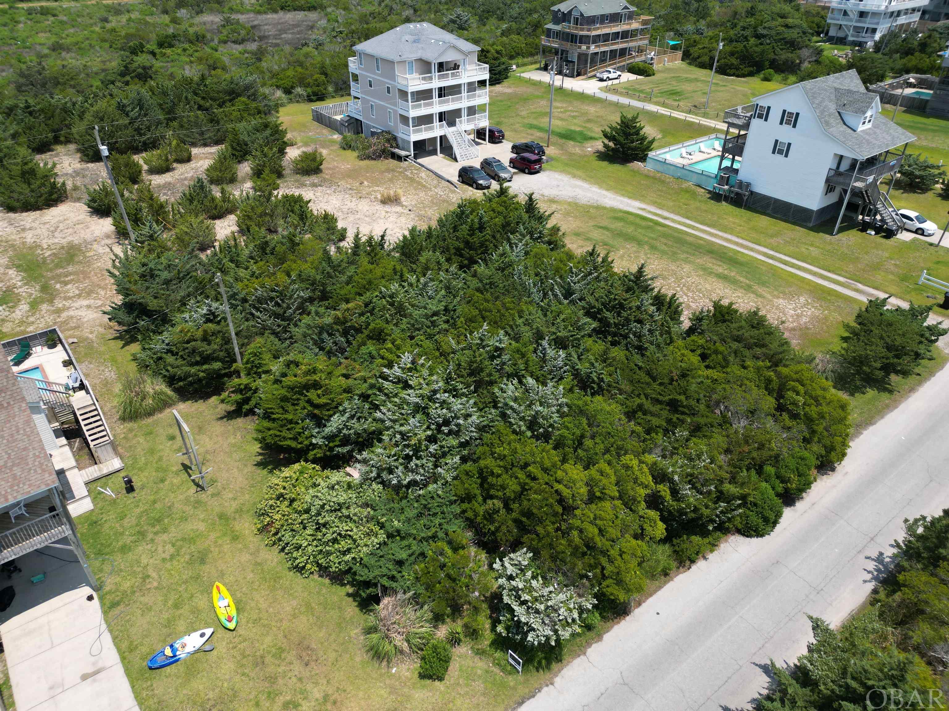 Could this be your last chance to purchase a vacant lot on this extraordinary street in Rodanthe?  Beautiful, partially wooded lot is waiting for your coastal dream home creativity. Short walk to the prestine beach, potential for glistening ocean water views and stunning sunset views; yet close to all of the shopping, restaurants, pier and countless water sport activities.  Don’t let this opportunity slip by you!