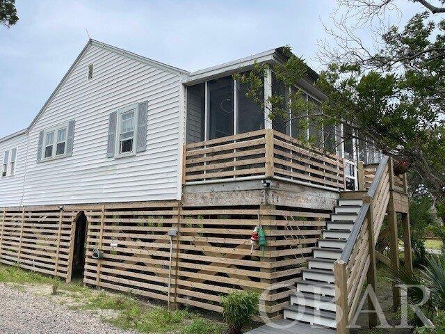 A 2 bedroom/1 bath home located on historic British Cemetery Road. Newly elevated to 10.5' (elevation certificate on request) with new pilings, composite front steps, composite decking on the large open back deck and a new outdoor shower. Canna Cottage is within walking distance to the harbor, restaurants, shops and island activities.  The home is a blend of old island charm and modern convenience. Amenities include: luxury vinyl plank flooring, central heat and a/c, gracious closet space, walk-in pantry, ceiling fans, large kitchen with access to the bright and cheery sun room with dining and sitting area. Bead board walls, shiplap bathroom, original interior doors with vintage knobs, large living room with access to a furnished screened porch and an oversized bedroom. Outdoor spaces include an open deck, screened porch, natural habitat (front of home), outdoor shower and grilling area. Canna Cottage was a rental home in the past and will be back on Ocracoke Island Realty's rental market for 2024.