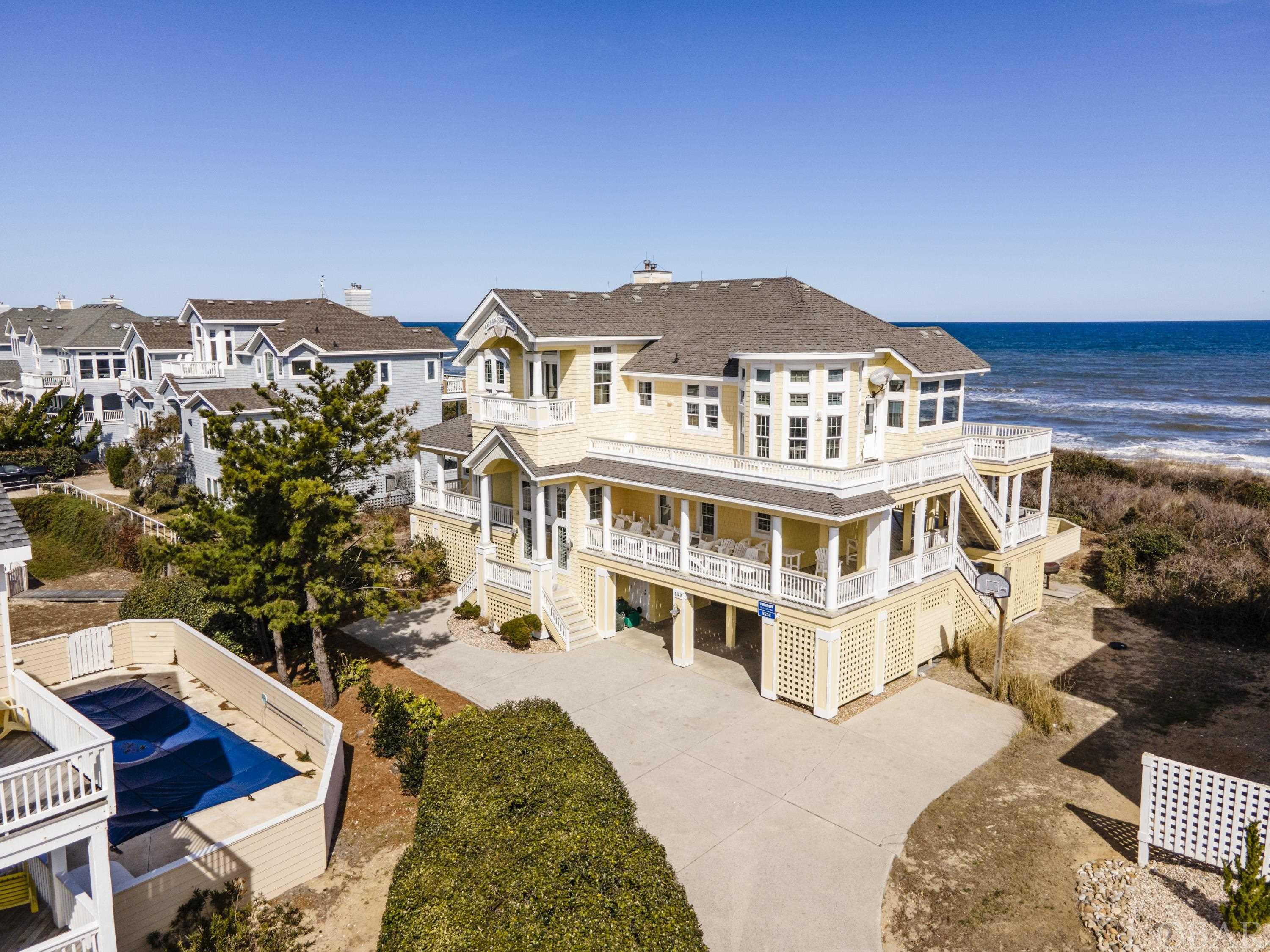 Welcome to Ocean Serenade, located on Salt House Road in the coveted Pine Island neighborhood of Corolla. Situated on an elevated lot with panoramic ocean to sound views, this stretch of beach is one of the most unique and highly sought-after locations on the Outer Banks. This meticulously maintained 7-bedroom, oceanfront home has been a proven rental producer for the original owner over the years. Loaded with private and community amenities including a private pool, elevator, rec room, and Control4 Smart Home features that allow you to control features of the house from your tablet and phone make this a rental investment that you don’t want to miss! Set up as a reverse floor plan, the top level boasts a large open layout with a fully equipped updated kitchen, great room, oceanfront reading nook, and a soundside upper-level loft with a private deck and a large ensuite bedroom. The middle level has 4 bedrooms (2 ensuite) which have access to the wrap-around deck where you can enjoy ocean to sound views while relaxing in the hot tub. On the ground level, you’ll find the two remaining bedrooms and a rec room that flows seamlessly outside to the large saltwater pool. Ask the listing agent for a pre-listing home inspection.