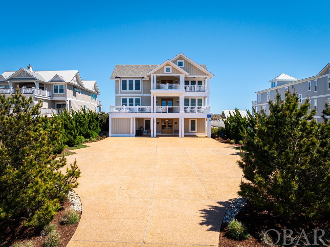 Welcome to 'Island Paradise.' Step inside, escape the ordinary and immerse yourself in a realm of opulence within this 11,800 square foot 12-bedroom oceanfront retreat nestled in the highly coveted Pine Island Reserve community of Corolla. Built by renown local Outer Banks Builder Olin Finch, Island Paradise is perfectly designed to host family vacations, corporate retreats or weddings, and exhibits an established and consistent rental history. Tranquility and rejuvenation await you within these walls, while expansive composite decks grace the exterior, overlooking the Atlantic Ocean sunrises to the east and the scenic sunsets of the Currituck Sound/Audubon Nature Preserve to the west. Marvel at breathtaking panoramic ocean views on the third level, where an expansive open layout offers sweeping vistas from the ocean living area, dining space, and large screened-in porch. On this level you will also find three master bedrooms, a sunset lounge room with custom Boat Bar overlooking to Audubon Nature Preserve, a half-bathroom, and a convenient elevator access servicing all levels. The second level boasts six additional master bedrooms, with an Oceanfront Lounge offering a serene retreat to unwind or enjoy private moments with loved ones, all within arm's reach of the coffee bar for refreshments. On the first floor, you'll find three more master bedrooms along with world-class entertainment havens and a pool bar room. A Theater Room equipped with NEW luxurious leather power reclining seats awaits the movie lovers, while the Arcade Room offers new & old era classics like Pacman, Big Buck Hunter, etc. A rec room featuring a pool table, shuffleboard table and a spacious Sports-Bar-style bar area leads out to a remarkable outdoor sanctuary complete with a covered outdoor kitchen, NEW poolside Tiki Hut, a half-bathroom, dining area, and large screened in lounge. While the mesmerizing ocean beckons just steps away via a private walkway, the custom pool stands as a serene retreat in its own right. Soak up some sunshine in the shallow lounging zone, warm up in the infinity-edge spa, or swim up to the poolside bar and enjoy a refreshing beverage. Showcasing itself as a proven rental investment, this home accepts rental bookings more than 51 weeks in advance. Full list of updates available upon request.