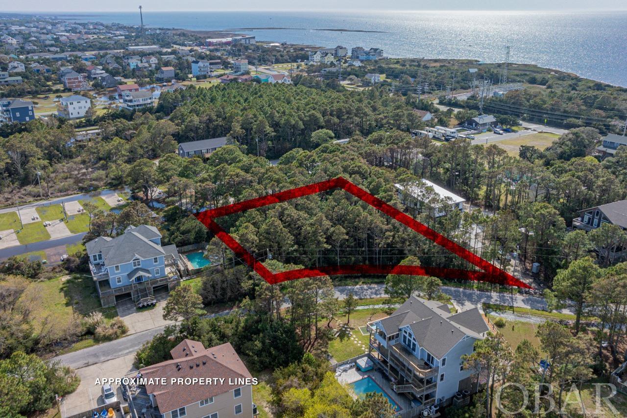 Discover the pinnacle of coastal living on this vast 20,000 square foot lot, nestled in a serene cul-de-sac within a breathtakingly beautiful subdivision just five lots away from the ocean. This wooded parcel offers the unique blend of privacy and accessibility, making it an idyllic site for your dream home. Embark on a leisurely stroll through the picturesque neighborhood to reach the deeded beach access. For water sports enthusiasts, the nearby Salvo Day Use Area provides convenient sound access, ideal for kiteboarding, kayaking, and soaking in the vibrant sunsets. Located on Hatteras Island, a renowned hotspot for kiteboarding, this lot lies at the heart of a water sports paradise. The iconic Cape Hatteras, perfectly positioned between the sound and the Atlantic Ocean, offers exceptional conditions for windsurfing, kiting, and winging. Enjoy easy access to local shopping, dining, and entertainment options, ensuring a blend of tranquility and convenience. Whether you're dreaming of constructing a primary residence, a vacation getaway, or a lucrative rental property, this lot provides the perfect canvas. Its generous size and strategic location promise unrivaled views of both the ocean and the sound, ensuring a living experience defined by natural beauty and leisure. Opportunities to own a piece of this paradise are rare. Take the first step towards realizing your dream lifestyle. Visit today and let the endless possibilities unfold on this spectacular lot. 4 Bedroom Septic permit on File