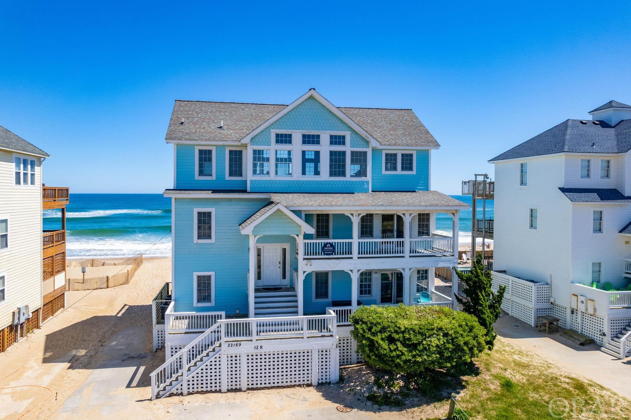 Located in the coastal town of Rodanthe, this 3300+ square foot oceanfront home boasts 7 bedrooms, 6.5 bathrooms, a game room with kitchenette, movie room, private pool, and most importantly panoramic ocean views! With ocean views from all levels, this open floor plan home features a spacious great room with cathedral ceilings, a recently remodeled kitchen with granite counters and stainless steel appliances, along with a breakfast island and pantry, while the adjoining dining area offers a picturesque setting for every meal.  The opposite side of the room offers incredible sunset views from a wall of mullioned windows and another seating area. Also on this level is an en suite bedroom with a private bathroom, ensuring the privacy and convenience of a reverse floor plan. On the middle level, there are four additional bedrooms, two of which are en suite bedrooms with private bathrooms, providing convenience and luxury for guests.  One en suite offers covered deck access to the west for sound views, and the other enjoys ocean front covered deck access. Two guestrooms share ocean side deck access and a Jack and Jill bathroom.  Vacationers appreciate this configuration as it offers plenty of space and a variety of sleeping options. The ground floor of Sun Runner is dedicated to entertainment and leisure, featuring a spacious game room with a kitchenette, a movie room, and two more guestrooms. The game room has ocean front deck access, offering more stunning ocean views, as does the pyramid bunk room.  A full bath is shared by this room and is accessible from the game room.  Another guest room enjoys front deck access and connects to a full bathroom, also accessible from the game room. Step outside to find the hot tub area and oceanfront pool, where guests can unwind after a day of beach-combing or simply revel in the soothing sounds of the waves. With its prime location, comprehensive amenities, and emphasis on breathtaking ocean views, Sun Runner promises a vacation experience to remember.
