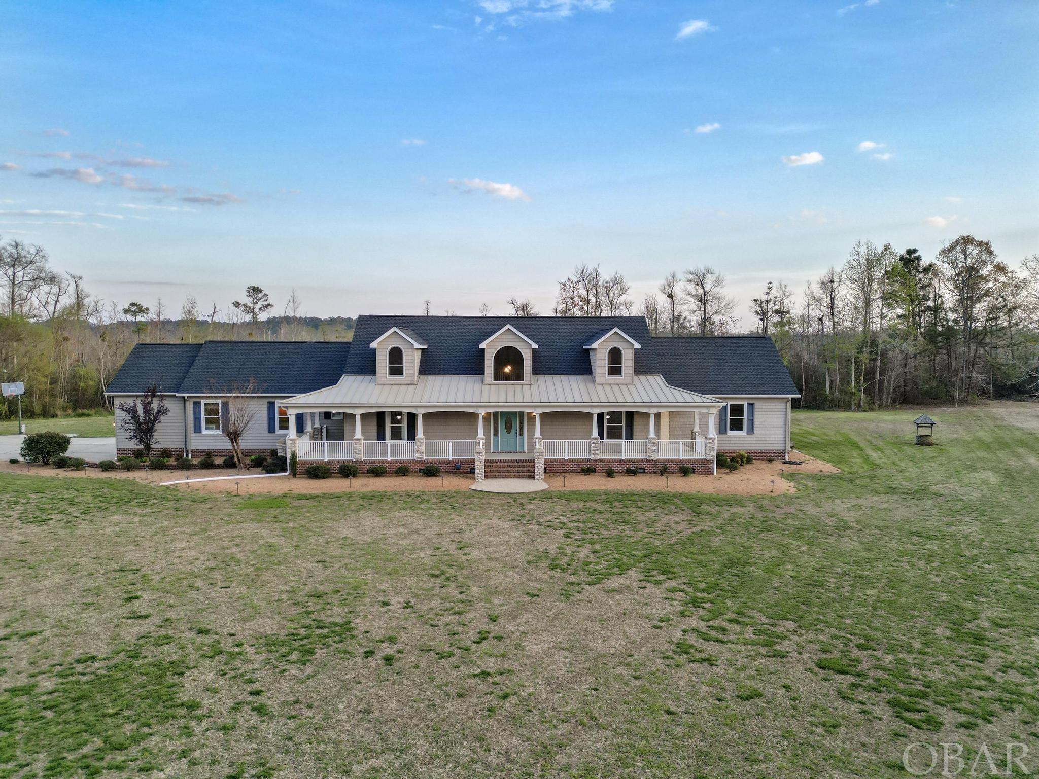 Property is comprised of 10.32 acres & features a 5,061 square foot house with 4 bedrooms and 3 full & 2 half bathrooms. House features a foyer, great rm, sunroom, dining rm, playroom, mudroom, & laundry rm. Double-sided stone fireplace in great rm & sunroom, Great room w/ surround sound wiring, built-in bookshelves & TV stand. Kitchen has custom cabinets w/quartz countertops, a commercial shaver ice maker, a Wolf pull-out microwave, & double oven, electric cooktop, dishwasher, pull-out trash bin, farm sink, pot filler. Eat-in kitchen w/a permanent table & bench stools. Grand bedroom has trey ceiling, office, custom walk-in closet w/washer & dryer, sink, large vault safe w/ample shelving & storage. Grand bathroom has jetted tub, 2 vanities w/sinks & ample storage, make-up table w/ quartz countertops, a tile walk-in shower w/ 2 shower heads, rain shower head, & spray jets, as well as a water closet., Upstairs has 3 large bedrooms, a hall bathroom with double sinks & quartz countertops, a large den/playroom with a storage closet, & a full bathroom with a tile shower & quartz countertops. Laundry rm w/custom cabinets w/quartz countertops, farm sink,& toilet. Double car garage w/cabinets & shelving, Outdoor area features a covered patio with kitchen that includes a grill, refrigerator, sink, & ceiling fan, all under a wood ceiling. Second covered patio off the sunroom is furnished w/Rattan furniture. There's a stone firepit w/sectional seating & gas propane hookup. Inground pool has a heater, along with a pool house. Property also features a cornhole/horseshoe pit, 3 detached garages with plenty of space, a covered shed for equipment, and a covered building for big farm equipment & workshop with a garage door. The property is fully landscaped, with four zones of irrigation in the front yard& a pump house. Crawl space is encapsulated & lighted. Property has a fully wrap-around porch w/stone columns. A rare opportunity to own a one of a kind home.