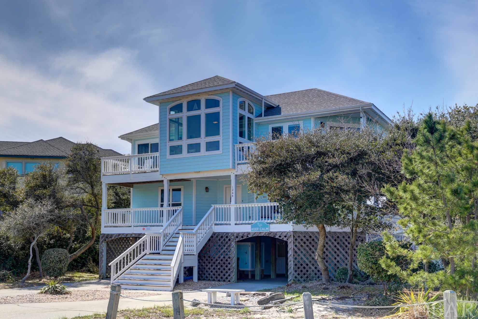 This Village of Ocean Hills, Semi Ocean Front home is a rare find. "Paws and Keep Calm" is absolutely ideal for the buyer looking for turnkey perfection located in the heart of Corolla! This completely upgraded and remodeled beauty is rental ready for the 2024 season.   This well laid out home is a favorite among guests and certainly appeals to the second home buyer looking for lots of space to spread out, expansive ocean views, incredible access to the beach and all of the amenities that Village of Ocean Hills offers. Nestled close to the Corolla estuary and the four wheel drive beaches, most famous for the majestic wild horses, the location is great for no matter what your interests are. Pristine, wide beaches that are quiet and private for the use of just the Village of Ocean Hills guests, it is no question why guests return year after year.   This home is well thought out in terms of layout. The top level (King) Master has sweeping views overlooking the ocean. Featuring built ins and a large private bathroom, it is bright and open. The **Brand New** remodeled kitchen is the perfect backdrop for entertaining and gathering for the whole family. The kitchen nook is bright and also features views of the ocean! The living room offers up a wet bar, plenty of gathering space with a seating to enjoy the best ocean views imaginable. Immediately off of the living room, enjoy decks for early morning coffee and late evening cocktails with calming views. There is a screened in porch on the top level for ping pong and a half bath at the top of the stairs! The mid level has four additional, well appointed bedrooms and two full bathrooms.   On the ground level, you will find an additional bedroom (and full bathroom) and rec room with a wet bar.   The game room opens up to a private (heated) pool, hot tub, grassy area for the pups and plenty of room for seating.   The Village of Ocean Hill Community offers: Oceanfront Pool (with bathrooms) Lakefront Pool (with bathrooms) Tennis Fitness Center Basketball court Sports Courts Catch and Release fishing  With lots of community amenities, major updates and solid rental income, this home checks all of the boxes!