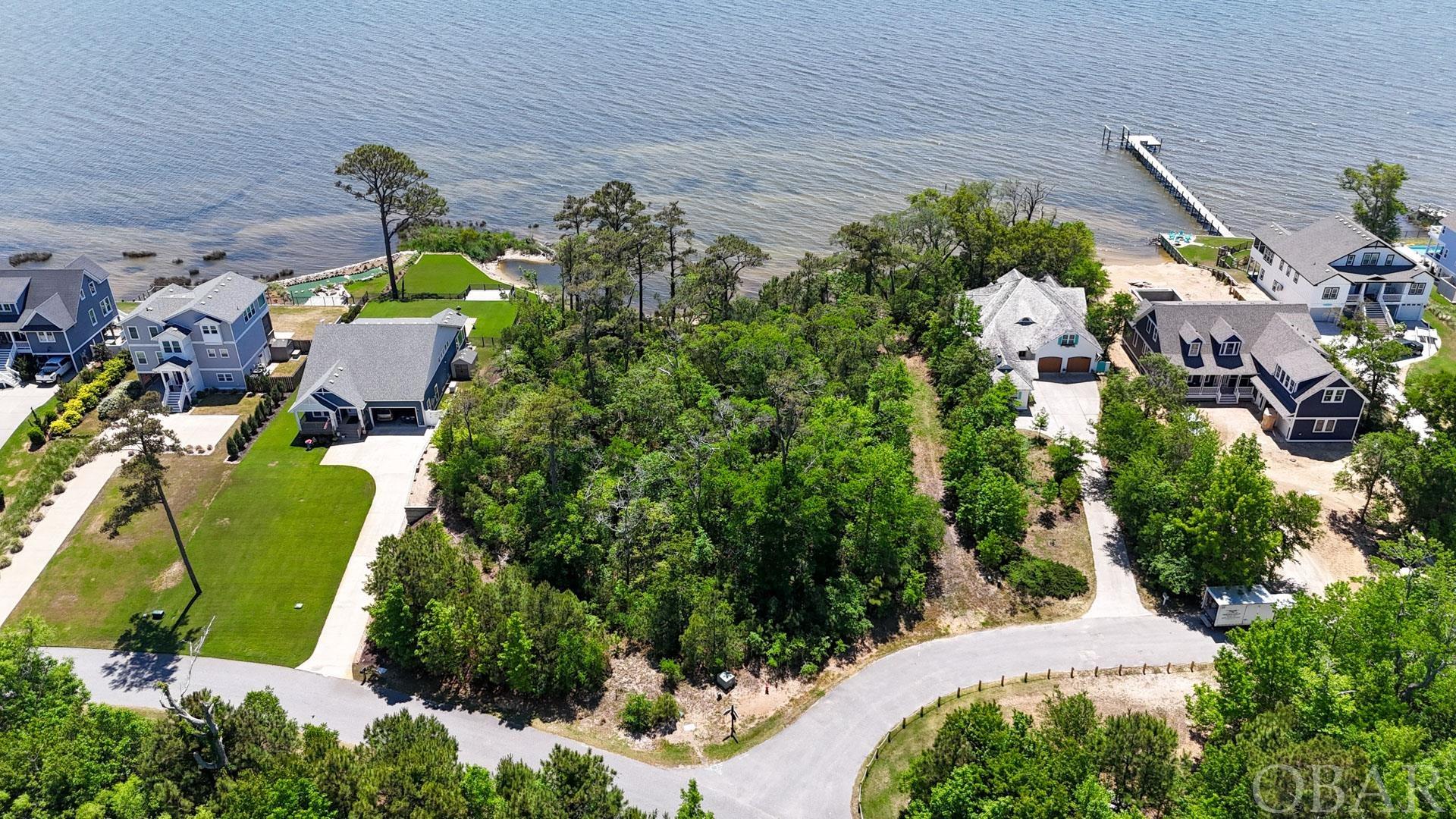 Beautiful sound front lot in the Carlyle Community! This large 17,500-square-foot lot would make the perfect location for your dream home. The lot is adjacent to the community sound access with amazing views over the Albemarle Sound. The majority of this lot falls in the X-Flood Zone setting you free from the need for flood insurance. Carlyle on the Sound emphasizes the need to preserve to natural foliage of the Outer Banks with 45% of the neighborhood being preserved as open space! Ask your agent about ready-to-build plans for this beautiful lot.