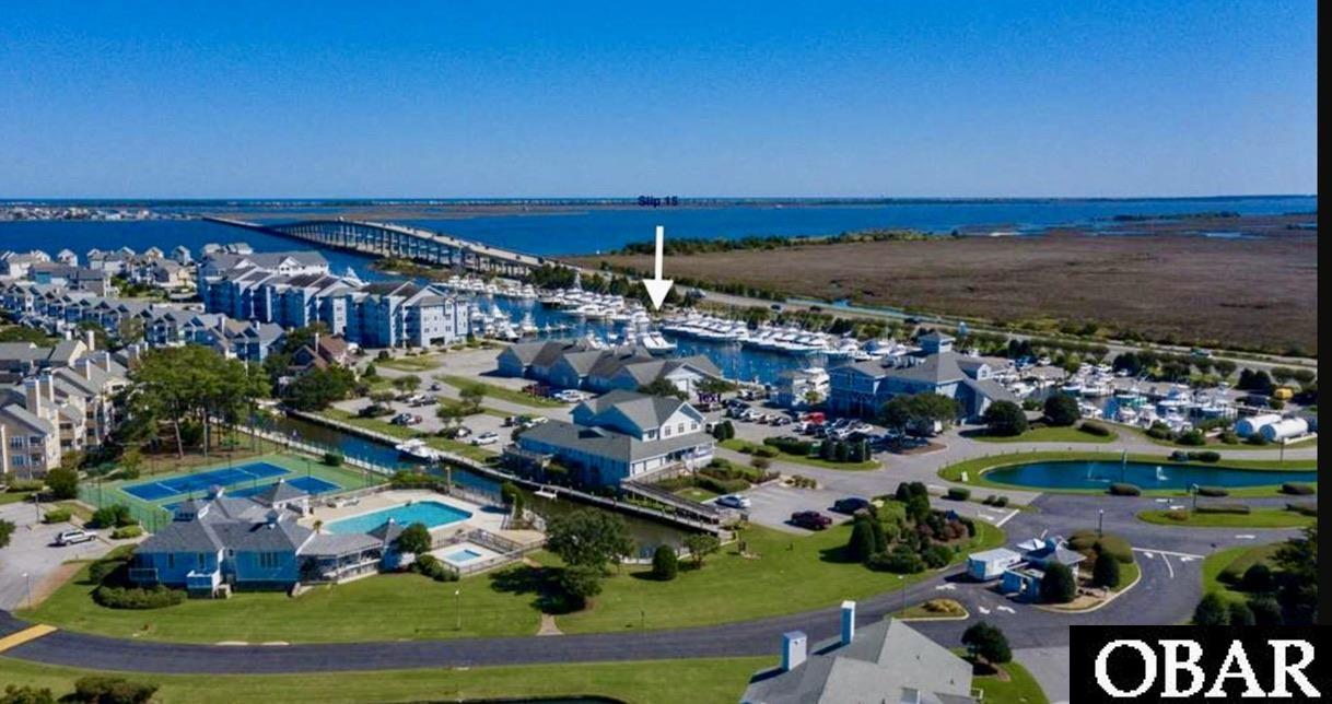 60 foot Boat slip in Pirate's Cove Marina.  The location of Slip 15 offers convenient fueling, access to the Ship’s Store, fish cleaning station and paved parking.  Pirates Cove is home to Bluewater Bar and Grill, a seasonal Tiki Hut and so much more!  Pirates Cove offers convenient access to Oregon Inlet, inshore and offshore fishing.  Slip Owners have the option to purchase amenity passes to utilize pool, playground, tennis & pickleball courts and the fitness center.  Slip measurements to be confirmed by buyer.