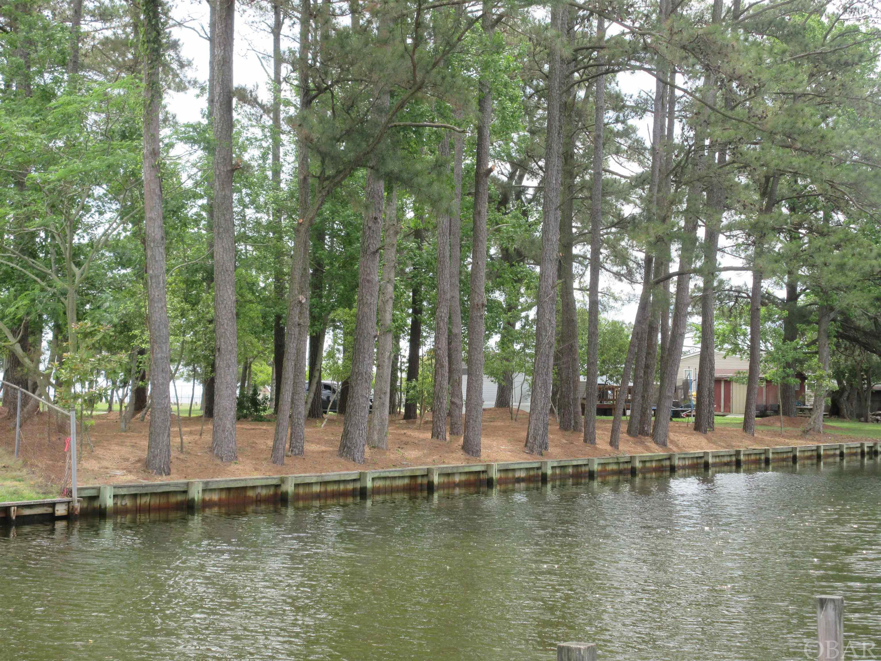 GET THE BEST OF BOTH WORLDS! Beautiful Water Views of the Currituck Sound overlooking the Barrier Island of the Outer Banks! Located on a Navigable Canal with direct Sound Access from this 150' Bulk Headed Canal front Lot!!  Great Elevation and truly A one of a kind Lot!  Build "your" Dream home and relax in this Waterfront Community, with a PRIVATE WATERFRONT PARK!  If you like boating this is you!  See this GREAT LOCATION  for an enjoyable Day on the water! Direct sound access from this lot provides you several Waterfront Restaurants nearby to enjoy, Barry's Restaurant is a short ride on the same side! Take a Day Trip and Explore the Island! Located 16.9 Miles by automobile (21 minutes) to Kitty Hawk and the Outer Banks Beaches/OBX! It's easy to enjoy the convenience of living in Grandy with Restaurants & Shopping near by yet only a short drive to Elizabeth City!  Chesapeake Expressway gets you there too!  Definitely a great spot to land if your a water lover!   Please call or Text when showing, this is a  Neighborhood Watch Community.  See this Lot TODAY!