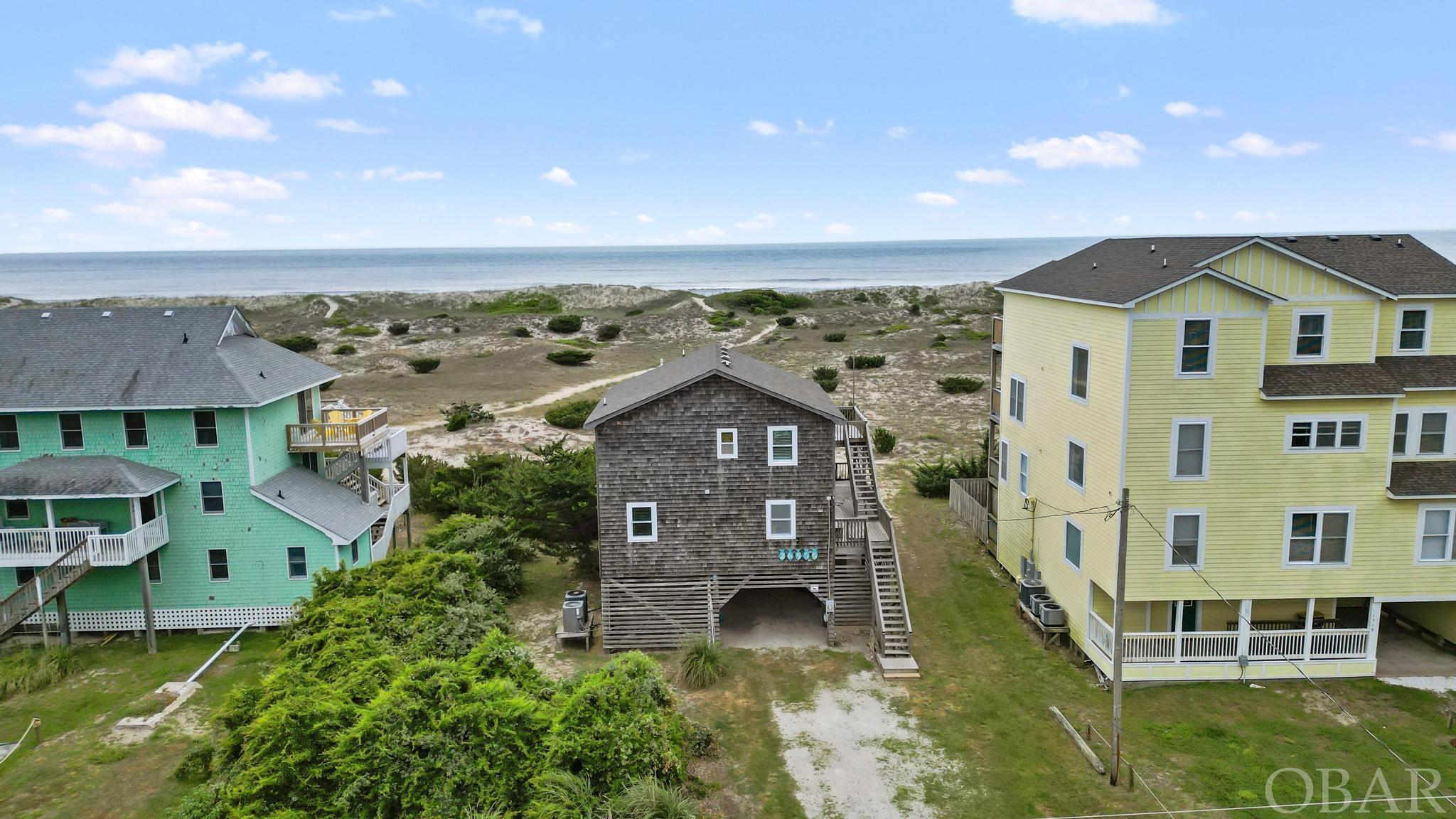 Welcome to your dream 80's turned beachy chic 2-story salt box on the Oceanfront in Salvo! "Always Remember" will captivate you as soon as you pull into the driveway. With its large & healthy dune line and ocean/seashore views for miles, you are sure to be instantly relaxed. Enter into the inviting foyer with access to all four bedrooms. One of which is a primary suite with access to ocean facing deck with Hot Tub. Three additional bedrooms on this level are comfortable and inviting with the stylish and fresh decor. Second level embraces the beautiful ocean views outside dual sliders. Large sundeck is perfect to catch those Summer Salvo sun rays. Newly updated kitchen features new cabinets 2023, new block counter tops 2023, ceramic tile backsplash 2023, and newer appliances. Newer LVP flooring makes it easy to clean up upon leaving your Haven. If you want a Vacation Home you will never forget, come and see "Always Remember"!