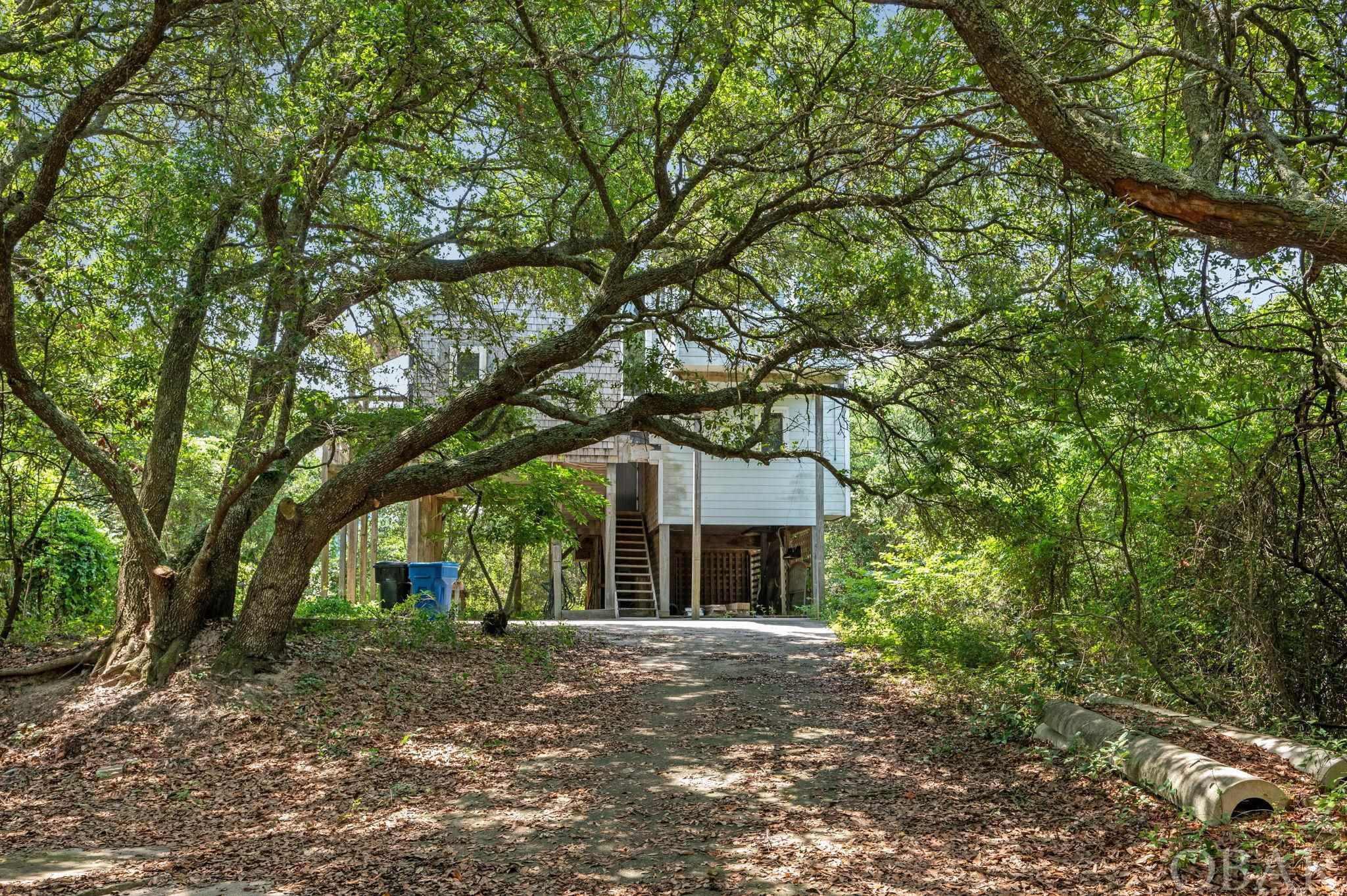 This fixer upper is in a sweet location in Duck! The large oceanside lot has great elevation and beautiful live oaks! The good: new roof, unique floor plan, price.  Needs attention: siding, decks, flooring, cosmetics.  SOLD AS IS for cash or rehab loan only.