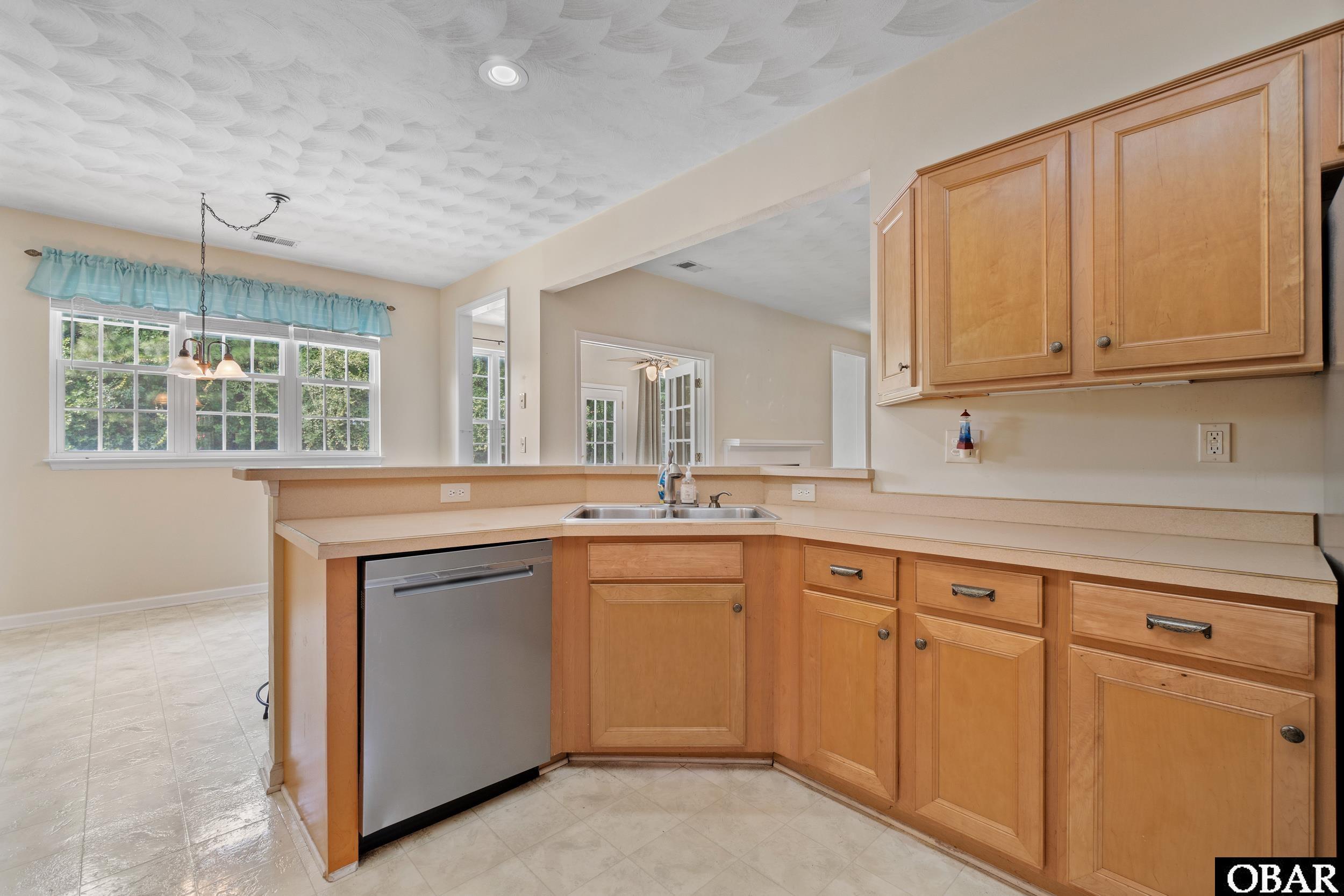 Sit-up kitchen bar open to living area and sunroom