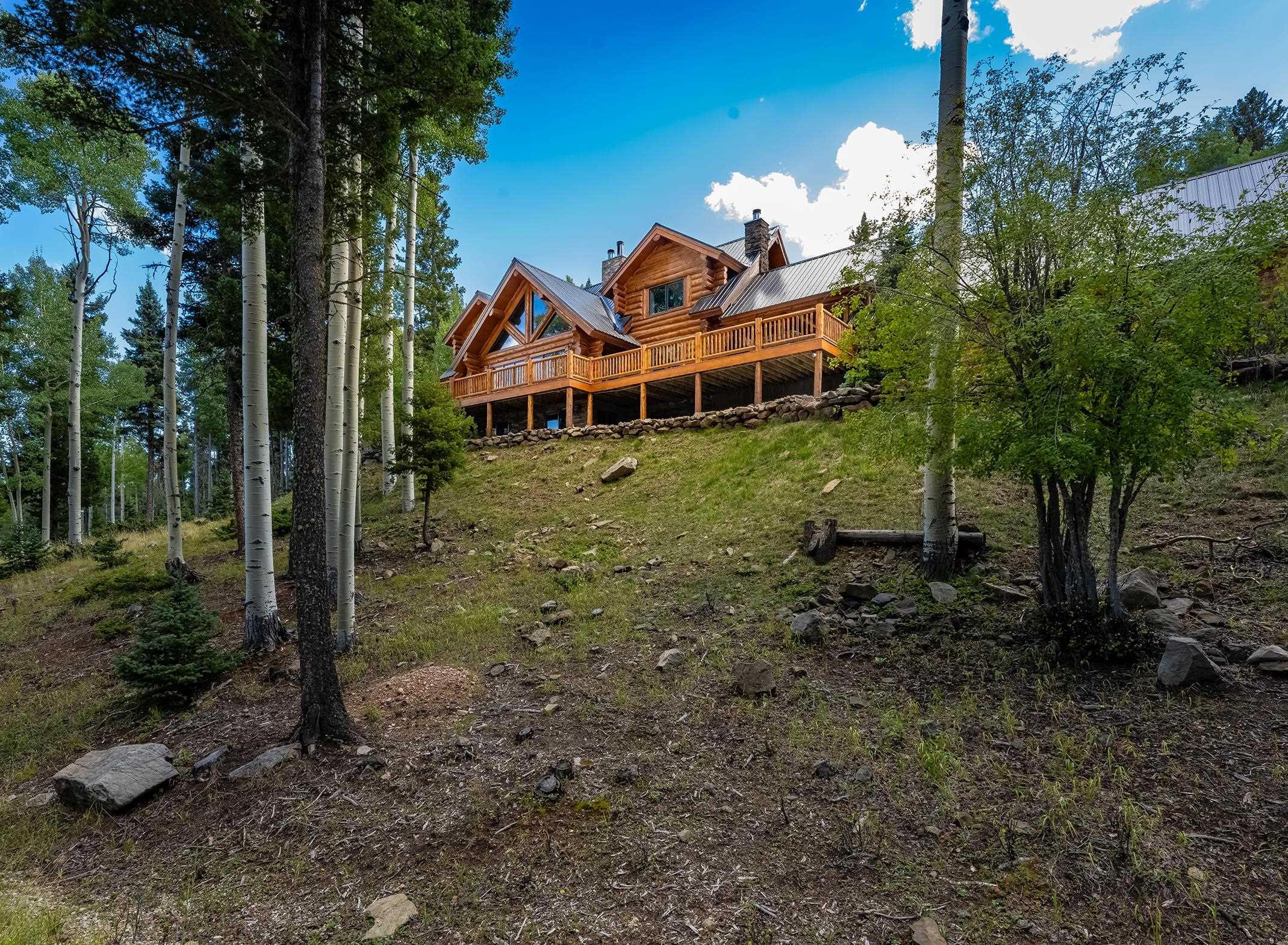 Dreaming of escaping to a luxurious retreat nestled high up in the mountain aspens? Look no further! This three-story luxury mountain log home offers the perfect combination of stunning natural surroundings, modern amenities, plus privacy and seclusion. Multiple living areas and master suites on each level make it convenient for multi-family gatherings. There are top-of-the-line appliances, soaring ceilings, grand fireplaces, and large windows that allow streams of natural light to flood the space. An expansive outdoor deck with a stone fireplace and dining area is perfect for enjoying breathtaking sunsets or hosting memorable moments. Enjoy viewing the wildlife while soaking in the relaxing hot-tub. Access to Carson National Forest is just a short distance away. New propanel seamless roof in 2021 is a plus for a new homebuyer. From sweeping panoramic views to  exclusive country club access to proximity to outdoor activities such as skiing, hiking, and fishing there is so much this dream property has to offer.