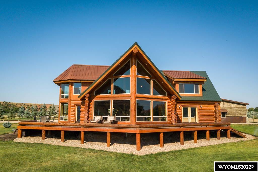 Live in a place you will never want to leave! This immaculate custom handcrafted log home is located in one of the most beautiful places in Wyoming. Every home chef dreams of cooking in a kitchen like this with stainless steel appliances, granite countertops, knotty alder cabinets and large island with additional sink and room for the whole family to be seated. Expansive views of the mountains and nearly a quarter mile of Ten Sleep Creek from almost every window bring the peace and tranquility of outside right into your home.  Imagine enjoying morning coffee while snuggling under a blanket, watching the sun rise over the Big Horn Mountains through the prominent east-facing windows of the open concept living area. The Primary En-Suite Bedroom also boasts wonderful sunrise views over the Big Horns with a seating area below one of its well-placed windows.  Attention to detail and pride of ownership shows in every aspect from the home to the entire grounds. The detached 3-car garage was built from locally reclaimed materials to achieve a modern rustic feel to match the property. You never know what wildlife will pop up in the yard; deer, ducks, geese, pheasants, muskrats, and mink just to name a few.  From the custom touches inside the home to the wrap-around decks, suspension bridge over the creek, pond, and garage, no stone was left unturned in the planning and execution of design. Some furnishings can be included in sale with acceptable offer. Owner carry financing possible, contact agent for details. More Photos Coming Soon!