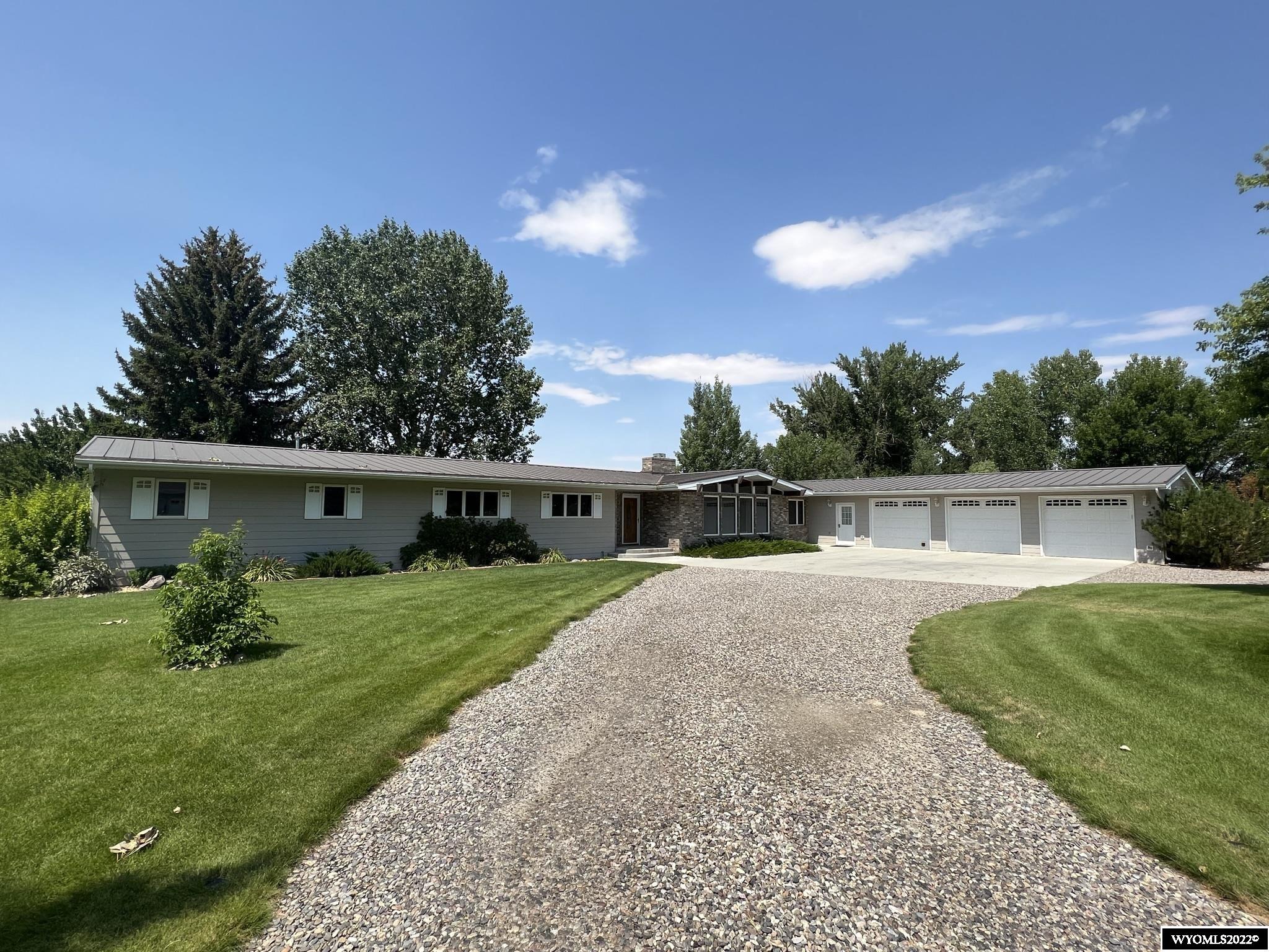 Amazing home on 1.62 acres right outside of Worland!  This spacious ranch has been meticulously maintained by the same owners for many years.  Home includes two master suites - one with huge 13'8" x 7'8" walk-in closet, jetted tub and walk-in shower.  Second has full bath and plentiful closet space.  Enjoy the beautiful views from the family room, kitchen, master bath, and den.  Living and dining rooms boast tongue and groove ceilings, and decorative wood beams flow throughout the main living spaces. This property continues to wow when you walk outside to the expansive grounds that have been carefully manicured to include beautiful mature trees and perennial plants.  The yard is irrigated from the Lower Hanover Canal by way of a recently updated pump.  The back patio is a perfect spot to sit and watch the sunset in the shade under the automatic awning.  Storage building perfectly matches main house and has a concrete floor, wall heater, and dog kennel.