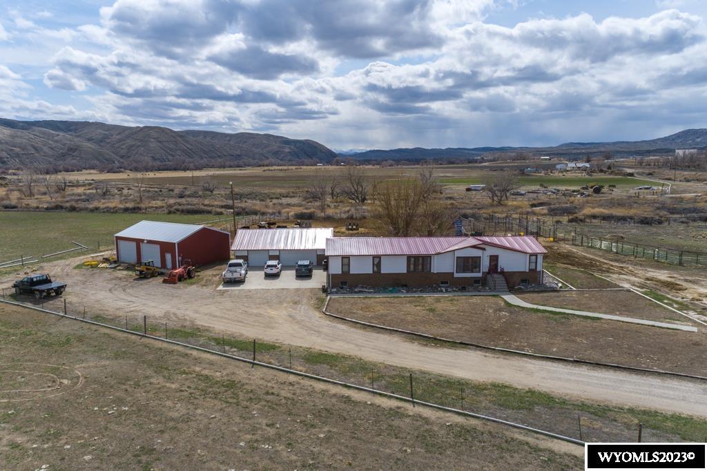 Welcome to this stunning western ranch situated on 40 acres of deeded land and 74 acres of Wyoming state lease. The spacious main house features 3 full bedrooms and 2 non-conforming rooms, perfect for use as an office, hobby room, or additional living space. The house also boasts solid Hickory wood floors, a large open living area with a wood stove, and breathtaking views of the surrounding countryside. Welcome to this stunning western ranch situated on 40 acres of deeded land and 74 acres of Wyoming state lease. The spacious main house features 3 full bedrooms and 2 non-conforming rooms, perfect for use as an office, hobby room, or additional living space. The house also boasts solid Hickory wood floors, a large open living area with a wood stove, and breathtaking views of the surrounding countryside.  The property includes a three-bay garage and a spacious two-bay shop, measuring 32 feet by 40 feet, providing ample room for vehicles, equipment, and storage. Live water flows through the property's southern side, providing a natural water source for livestock and wildlife. The ranch also features 8 acres currently under gated pipe irrigation, powered by a 3-phase pump.  This property is a unique gem, blending modern amenities with the rugged western lifestyle. Don't miss out on this incredible opportunity to own a piece of the wild, untamed west.