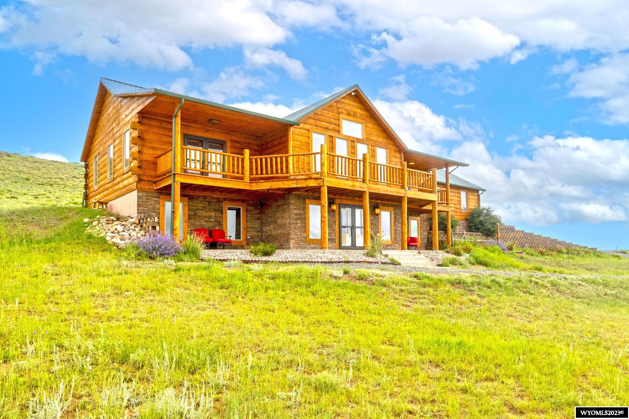 Prepare to be captivated by the sheer beauty of this remarkable property. Built in 2015, this custom log home spans 3,864 square feet in the main house, offering a spacious and inviting sanctuary. With 4 generously sized bedrooms, 3 bathrooms, and ample living space, this home ensures comfort and relaxation for all. Step into the main living area, where vaulted ceilings and four expansive south-facing windows bathe the space in natural light, while treating you to breathtaking views of Lake Hattie and Sheep Mountain. Revel in the warmth of the wood burning fireplace, gracing the main level, while the stunning wood floors throughout the upper level add a touch of elegance. The kitchen boasts exquisite and low-maintenance granite countertops, enhancing both functionality and aesthetics. This property also features an impressive 62 x 28 outbuilding, serving as a three-stall horse barn, a workshop, and a 840 square foot fully-furnished guest apartment above. The 2 bedroom apartment is equipped with all the necessary appliances for effortless living, making it ideal for guest visits.