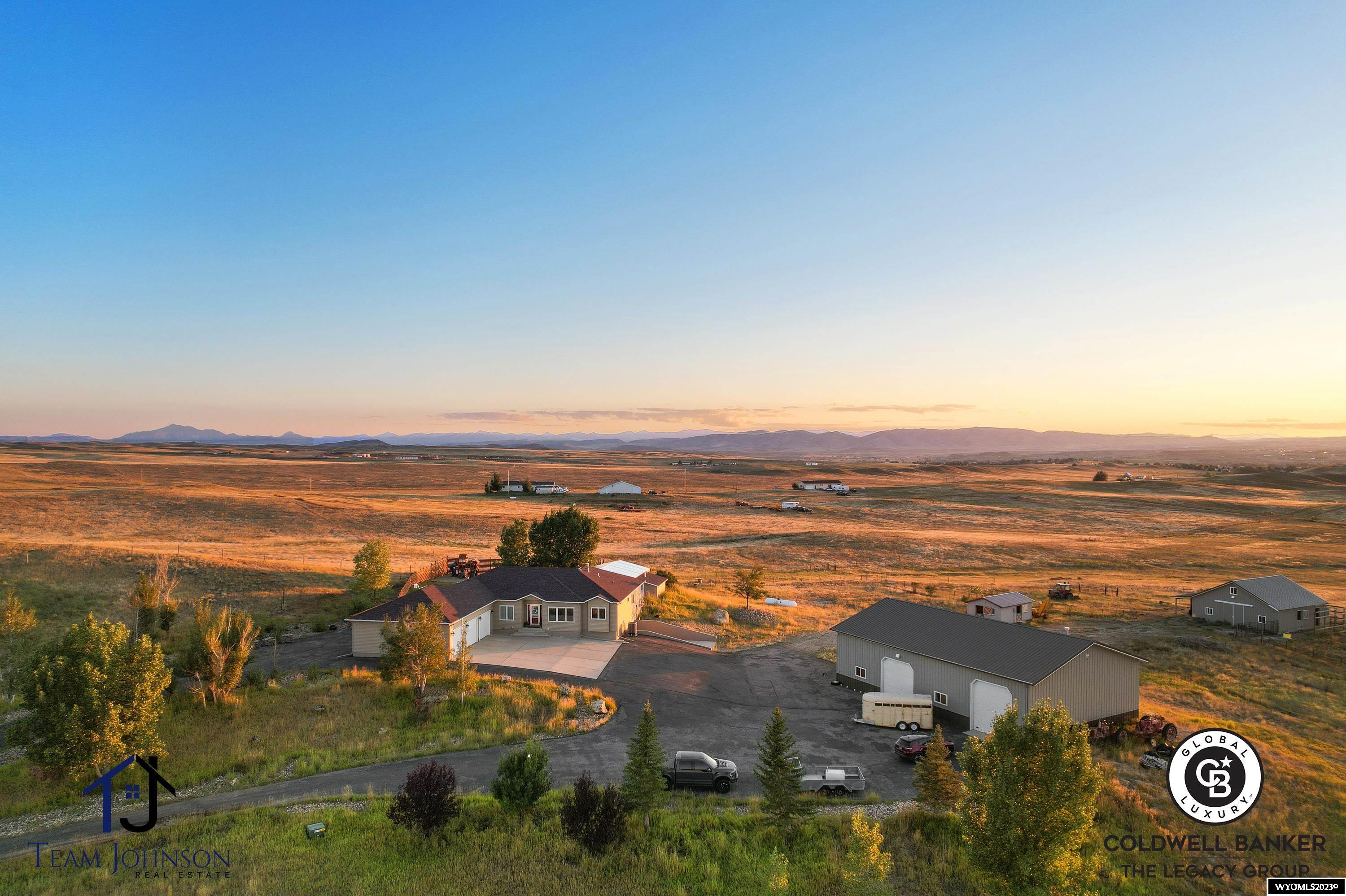 Experience Wyoming living at its best with this extraordinary ranch-style home nestled on nearly 24 acres. Boasting an expansive 5,440 square feet of living space, this magnificent residence offers a harmonious blend of luxury, functionality, and natural beauty.  As you step inside, you'll be greeted by an abundance of natural light, highlighting the elegant hardwood floors and open floor plan. The heart of this home is the kitchen adorned with cherry wood cabinets, gleaming granite countertops, top-of-the-line stainless steel appliances, a gas range, and a sub-zero refrigerator. This culinary haven seamlessly flows into a spacious dining area and the main living space, complete with a cozy gas fireplace.  The main level offers an impressive 5 bedrooms, including an elegant primary suite featuring a coffered ceiling and an opulent bathroom with a jacuzzi tub, and a spacious shower.  Two more bathrooms and a mudroom with ample storage space completes the main level. Descending to the walkout basement, you'll discover an entertainer's paradise. A generous family room awaits, equipped with a projector and screen and a wet bar. There's also a dedicated gym space and two more bedrooms, along with a fourth bathroom, making this level perfect for hosting guests.  This home also includes an enclosed, heated pool with a hot tub and a retractable wall that leads to the backyard, ensuring year-round enjoyment and relaxation. An attached three-car garage, with two stalls being drive-through, provides ample space for your vehicles and storage needs. The property also includes a remarkable 42x68 square foot insulated and heated shop with car lift, featuring additional living quarters with a convenient kitchenette and a beautiful ¾ bathroom. This versatile space is perfect for hobbies, projects, or accommodating guests. Furthermore, a 16x24 farm utility building and a 36x36 barn with loft space offer endless possibilities for your agricultural or storage needs. With its expansive acreage, luxurious amenities, exquisite attention to detail and just 5 minutes from town, this Wyoming dream home is truly one-of-a-kind. Don't miss the opportunity to make this unique property your home.  Contact Team Johnson today to schedule a personal tour.