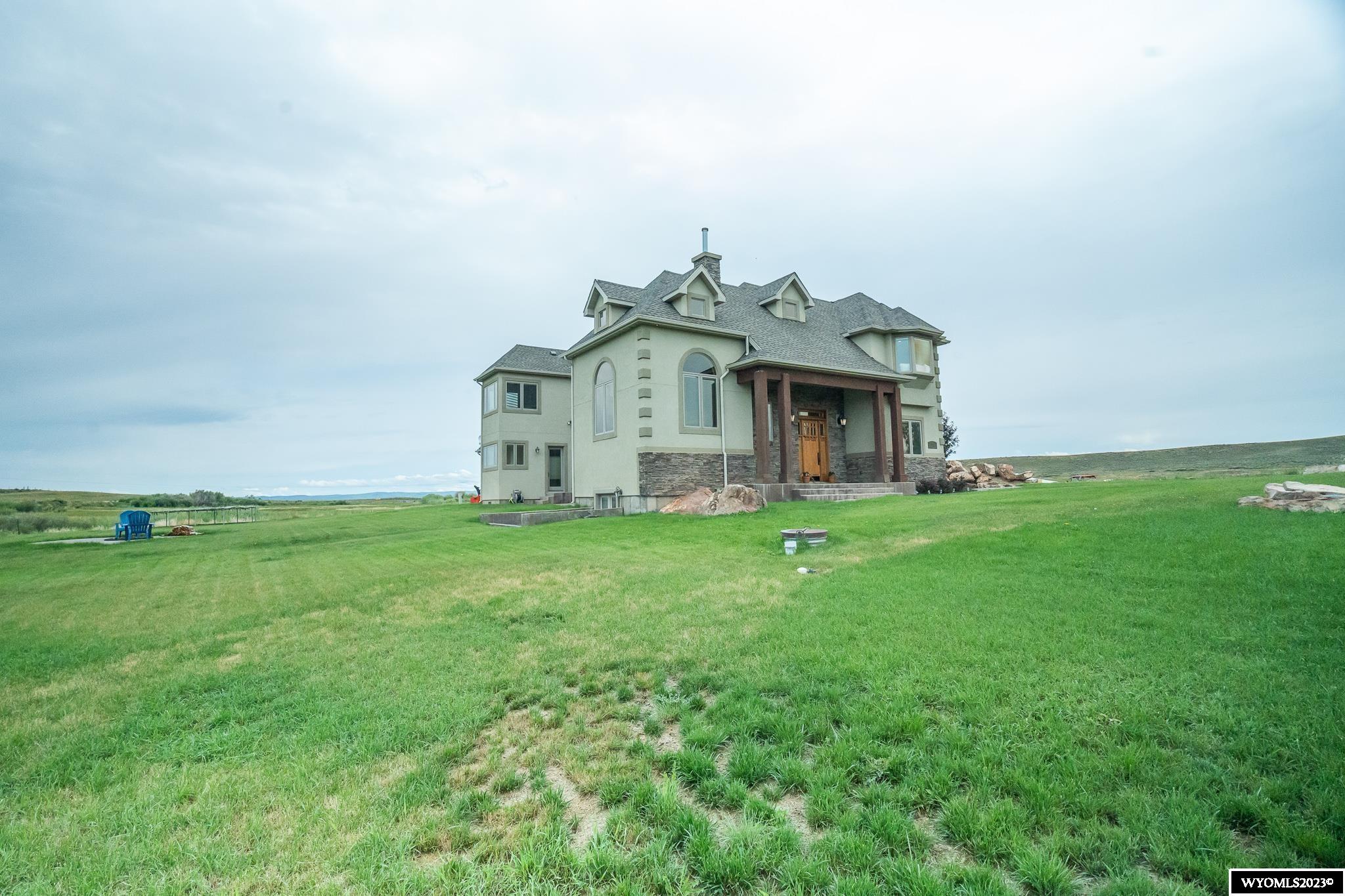 This elegant single family home sits on 32.91 acres in beautiful Wyoming. 15 minutes north of Evanston, and minutes to"Wyoming Downs" horse racing. A private entrance, large dirt bike track, irrigation canals around the property, chicken coop, fire pit, and irrigated pasture land. Upon entrance, you are warmly greeted by title/laminate floors, huge chandelier, and open floor plan seamlessly connecting the kitchen to the living room and leading to the inviting, beautiful backyard. Meticulous attention to detail is presented in the open kitchen, with granite counter tops, commercial grade appliances, a warming tray, drink cooler, and a built in Espresso Machine. Adjacent to the living room, there's a comfortable bedroom with a joining bathroom and an office/library with a fireplace. Upstate you'll find two bedrooms with a bathroom and the Master Suite. Beautiful views, his and her own walking closet, bathtub/jacuzzi with color lights, double shower with a steamer, . Downstairs is an extra room currently used as a gym, half bathroom, and a bar. The backyard is quiet, peaceful,and a large patio provides plentiful space for entertaining. The home is equipped with speakers and sound system in all bedrooms and family room