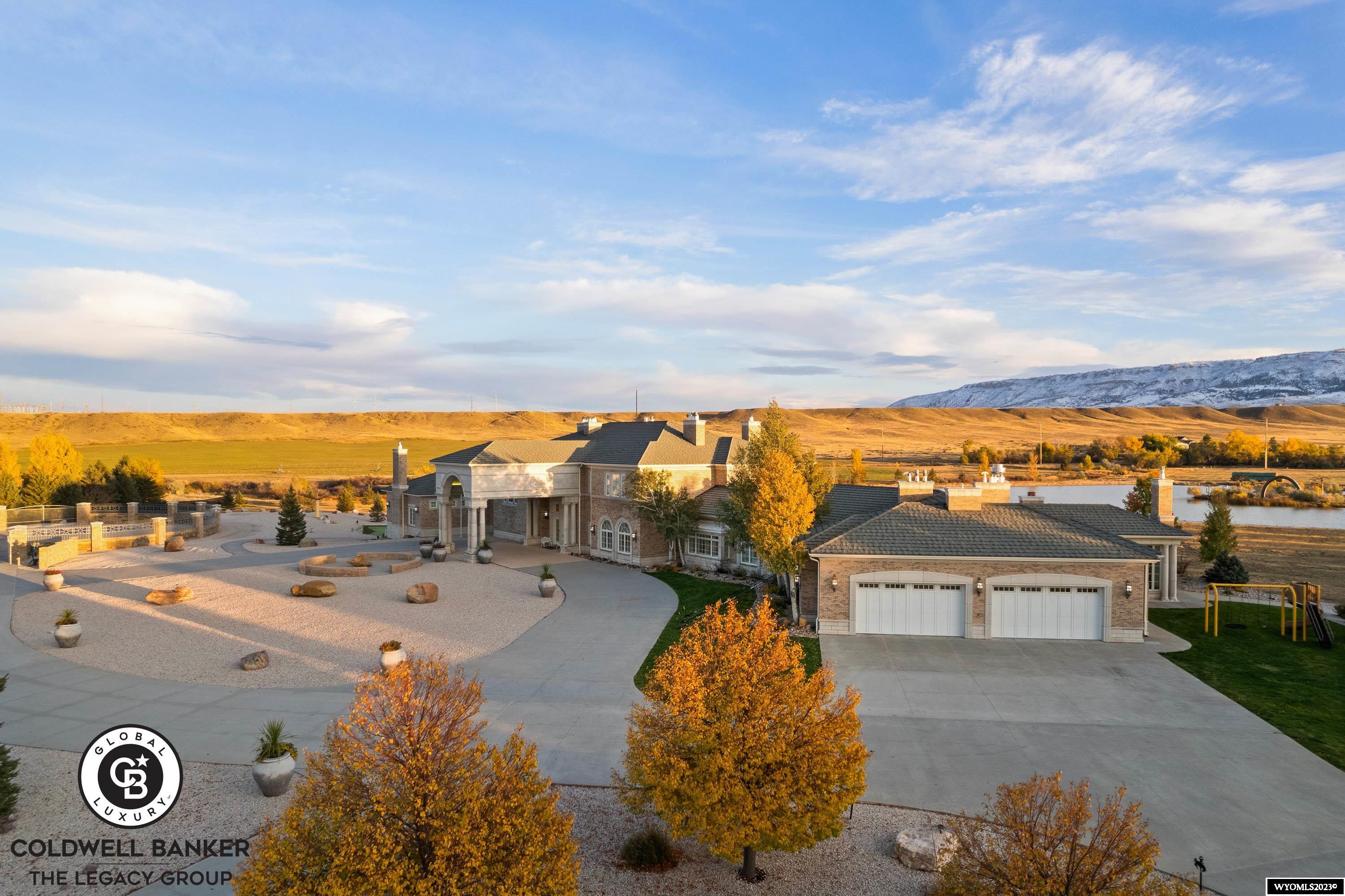 Welcome to Wyo Manor, an enchanting 22,000± square-foot estate thoughtfully designed for luxury living, business, and entertainment. Each room is a warm masterpiece with tall ceilings and south-facing windows elegantly framing the mountain views. Upstairs, a regal private office and conference room streamline business operations. The estate boasts spacious guest suites, a luxurious primary suite, an ornate kitchen, grand living and dining areas, and a banquet hall for up to 100 guests, with an outdoor patio. A separate guest home offers private quarters for long term guest stays or VRBO potential, and the grounds feature an exclusive waterfall and pond with a walking path. The 5-stall garage attached to the guest home is a car collector’s dream with radiant heat, floor drains and plumbing for pressure wash and compressed air. This mansion's prime location near the North Platte River and Hogadon Basin Skiing provides abundant recreational opportunities. Wyoming residents enjoy no state income tax, a low population, and vast open spaces. Wyo Manor presents the opportunity to live in luxury while establishing a business and making a sound investment. See it today with Dorie G Nelson (307-267-1190) or Tommy Russell (307-267-7606).
