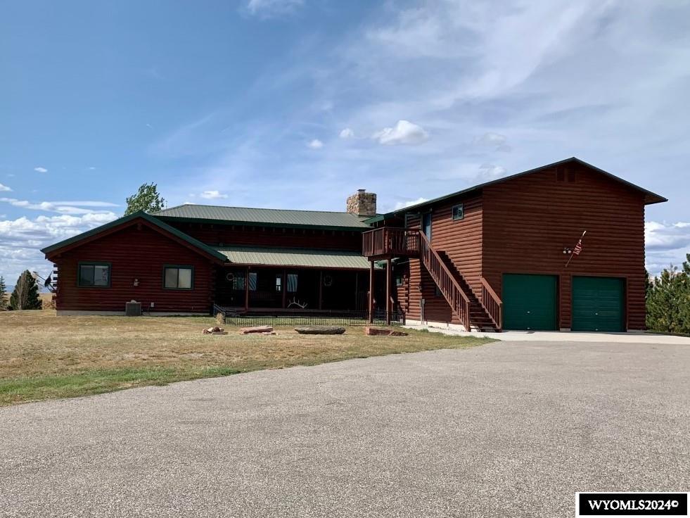 The Little Yellowstone has a custom-built log home on 80 acres. This 2-story home has 5 bedrooms and 3 1/2 bathrooms. The great room has vaulted ceilings, wood floors, and a double-sided fireplace. The spacious kitchen features hickory cabinets and wood floors. There is a breakfast bar, double oven, two refrigerators, and a walk-in pantry.  The dining room is open to the kitchen and the double-sided fireplace. The master suite features a spacious bedroom with vaultedceilings, walk-in closet, and a private entrance to the covered deck. The five-piece bathroom has double sinks, a soaking tub, and a step-in shower with double shower heads. There is an additional bedroom, an office or fifth bedroom, and a full bathroom on the main floor. Upstairs, is a loft overlooking the great room, two bedrooms, and a full bathroom. Additional amenities include main floor laundry, central air conditioning, two on-demand water heaters, and a metal roof. You will enjoy having coffee and watching the sunrise from the covered front porch. To the west is a covered deck and a shelter belt with mature trees. The 2-car attached garage has been partially converted to a mudroom but can easily be changed back to fit your needs.  There is a 694 SF studio apartment with a private entrance located above the garage.  It features a full kitchen, breakfast bar, and 3/4 bathroom. Outbuildings include a 3200 SF Quonset, a 5-stall open-faced barn, a round pen, and a granary.  Located 13 miles east of Wheatland with 80 acres of pasture that is fenced and cross-fenced. Call Lisa Cochran at 307*331*2325