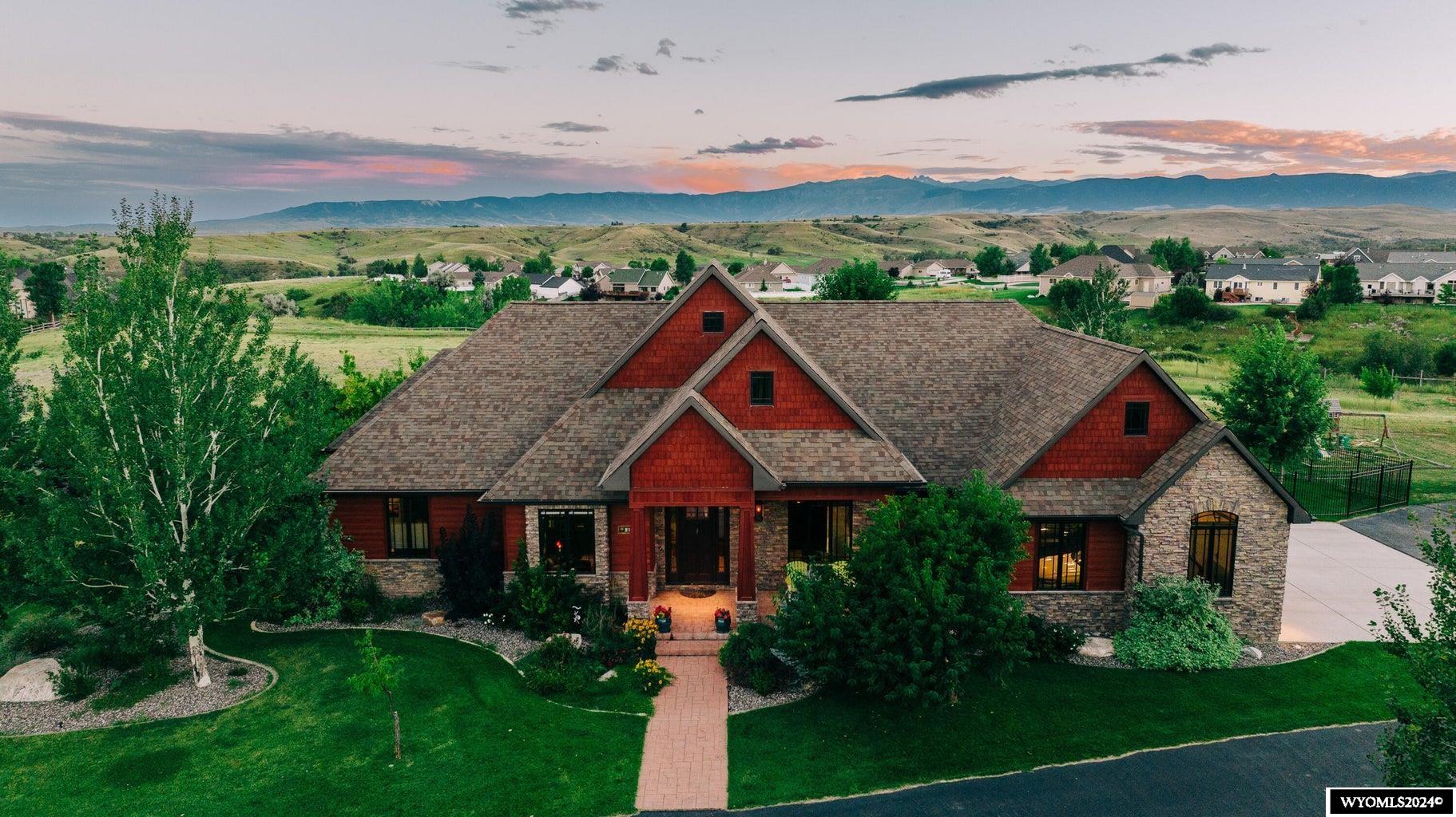Elegance inspired by the Arts and Crafts movement of the mid-19th century is characterized by clean lines, tapered columns and beautiful built-ins to maximize storage throughout this four-bedroom, five bathroom, modern craftsman style home. Life will easily revolve around the spacious open floor plan of the chefs kitchen, dining and living room with picturesque views of the Big Horn Mountains that one can enjoy while perched in front of the wood burning fireplace. Some of the homes features include hand scraped hickory floors, quarter sawn oak cabinetry, onyx & soapstone countertops, stunning vintage light fixtures, coffered ceilings, Irish wallpaper in the sunroom and a surround sound system.  The curved rolling ladder in the library provides easy access to the built-in shelves and creates a cozy ambiance for a home office that is located off the front entry. You will find the main level primary bedroom to be very generous in size with amenities such as crown molding with coved lighting, a unique gas fireplace, a large walk-in closet, en-suite bathroom with radiant floor heat, jetted tub and walk in wall jetted shower. The walk out basement contains the perfect entertainment area with a well- equipped bar, large family room two bedrooms and two bathrooms. The heated three car attached garage and 2160 detached garage have more than adequate space for vehicles, toys and additional storage. All of this located on 9.66 acres in town with thoughtfully landscaped areas surrounding the home, native landscape on the majority of the property and fantastic wildlife viewing. Highland Park Elementary, Sheridan High School, walking trails, restaurants, and the hospital are all within minutes of this amazing location. All measurements are approximate.
