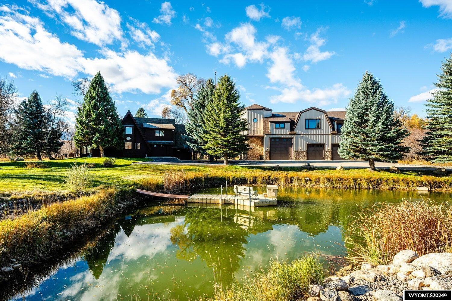 Welcome to the perfect blend of luxury and tranquility at this well positioned creekside property. This private location offers seclusion with convenient town and mountain access for an unbeatable active lifestyle, plus a large attached shop space for storing your outdoor toys and vehicles. The property spans 4.34 acres with captivating views of Big Goose creek, the Bighorn mountains and surrounding natural spaces. Stepping into the home, you're greeted by an impressive foyer that leads upstairs to a light filled office with outdoor access that connects the two homes. The upper level includes a gourmet kitchen, living room, dining room, primary suite, laundry and a second bedroom. The sky-high ceilings in the living room allow natural light to pour in from multiple windows, illuminating the two-story stone-clad fireplace. The serene primary suite offers a sitting area, outdoor access, two walk in closets and a luxurious ensuite bathroom. The main level features a family room, third bedroom and bathroom. Outside, unmatched outdoor living space, including creek side paths, a trout filled pond and a quaint two bed two bath guest house. This is truly a property you will fall in love with the moment you arrive. All measurements are approximate....
