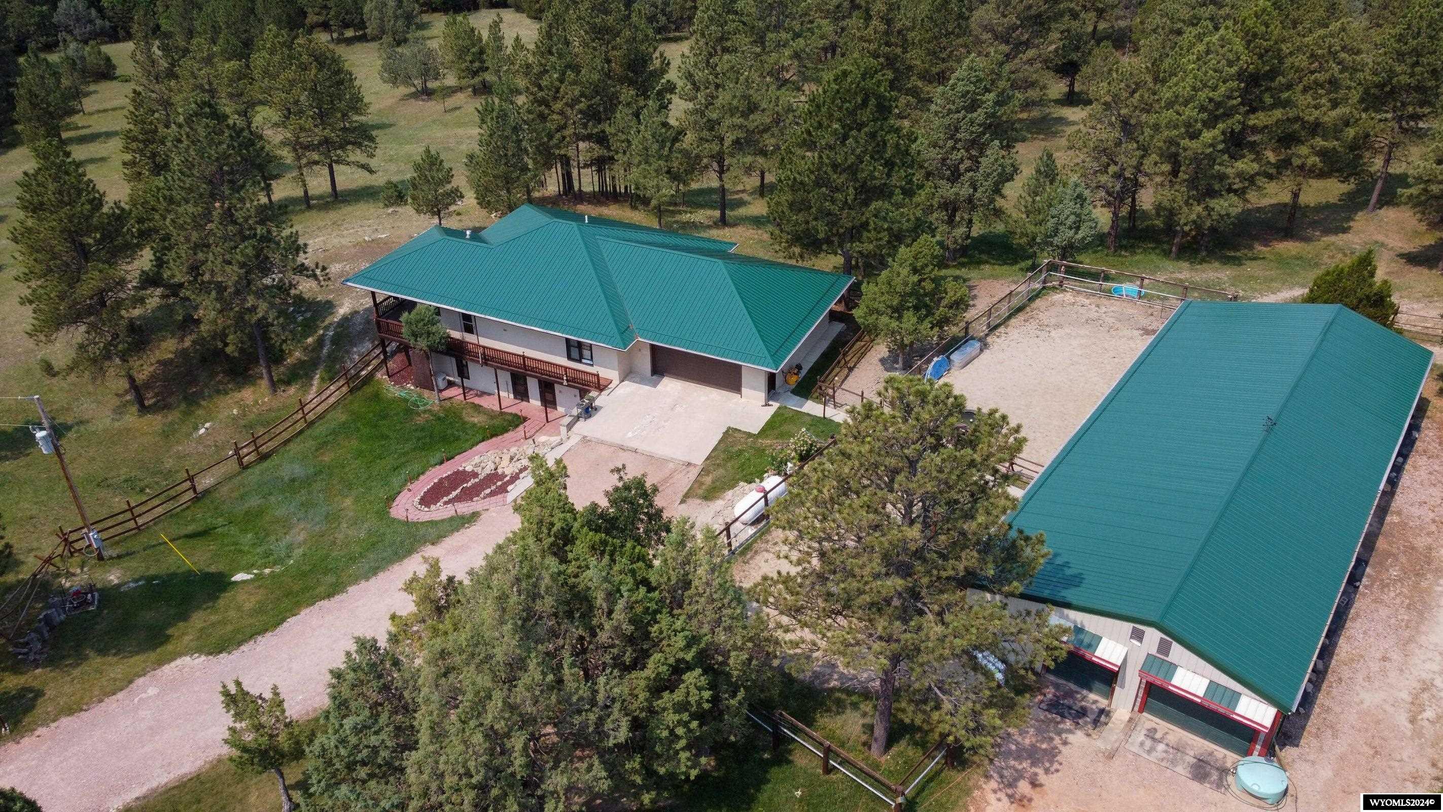 Discover your dream home on a sprawling 77-acre estate offering luxury, comfort, and seclusion. This stunning four-bedroom, two-bathroom residence features an open-concept design with elegant tile and hardwood floors, complemented by in-floor heating. The property includes a heated two-car attached garage, a heated barn, and a heavy-duty protective tarp-type shed. Enjoy the peace of mind with two water wells and a versatile office/laundry room. The walk-out basement can be converted into a separate living space. Relax on the covered deck and savor scenic views surrounded by mature trees. Unique to this property, a dinosaur skeleton was discovered and excavated here, adding historical intrigue. Embrace the opportunity to own this peice of paradise.