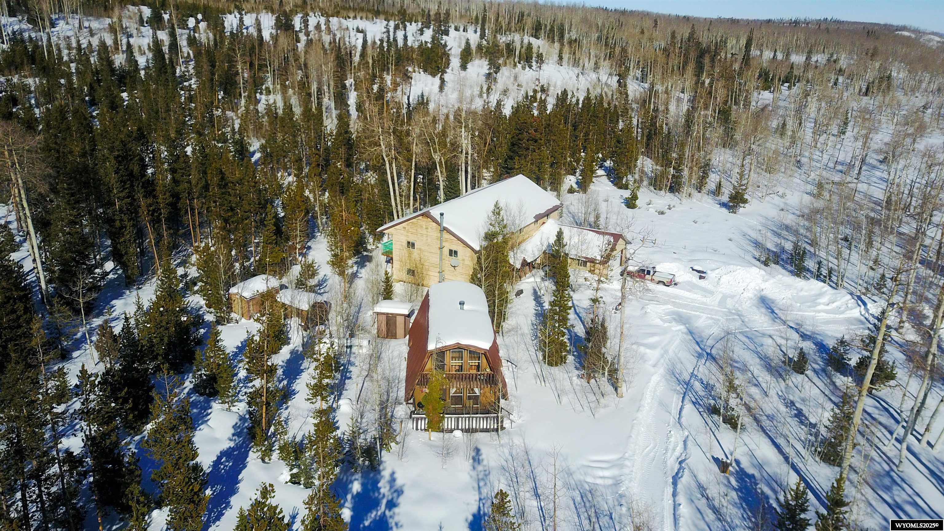 Discover the charm of this exceptional property, featuring two distinct cabins that blend rustic allure with modern elegance. The modern cabin boasts a stunning custom kitchen equipped with pull-out deep cabinets, a double oven, and luxurious in-floor heating throughout both levels. Enjoy the cozy ambiance provided by a wood fireplace, with the potential for up to 5 bedrooms and 4 bathrooms to accommodate family and friends. The three bedrooms upstairs all come with their own bathrooms, walk-in closets, and secluded balconies, offering a private retreat. Meanwhile, the rustic cabin offers a warm and inviting atmosphere with a kitchen, dining area, and living space on the main floor, along with one bedroom and bath. Upstairs, you’ll find 2 additional bedrooms and a loft, perfect for relaxation. Transform this unique dream oasis into your reality and create cherished memories for a lifetime. For inquiries or to schedule a showing, call Cowboy State Realty at 307-200-4332.